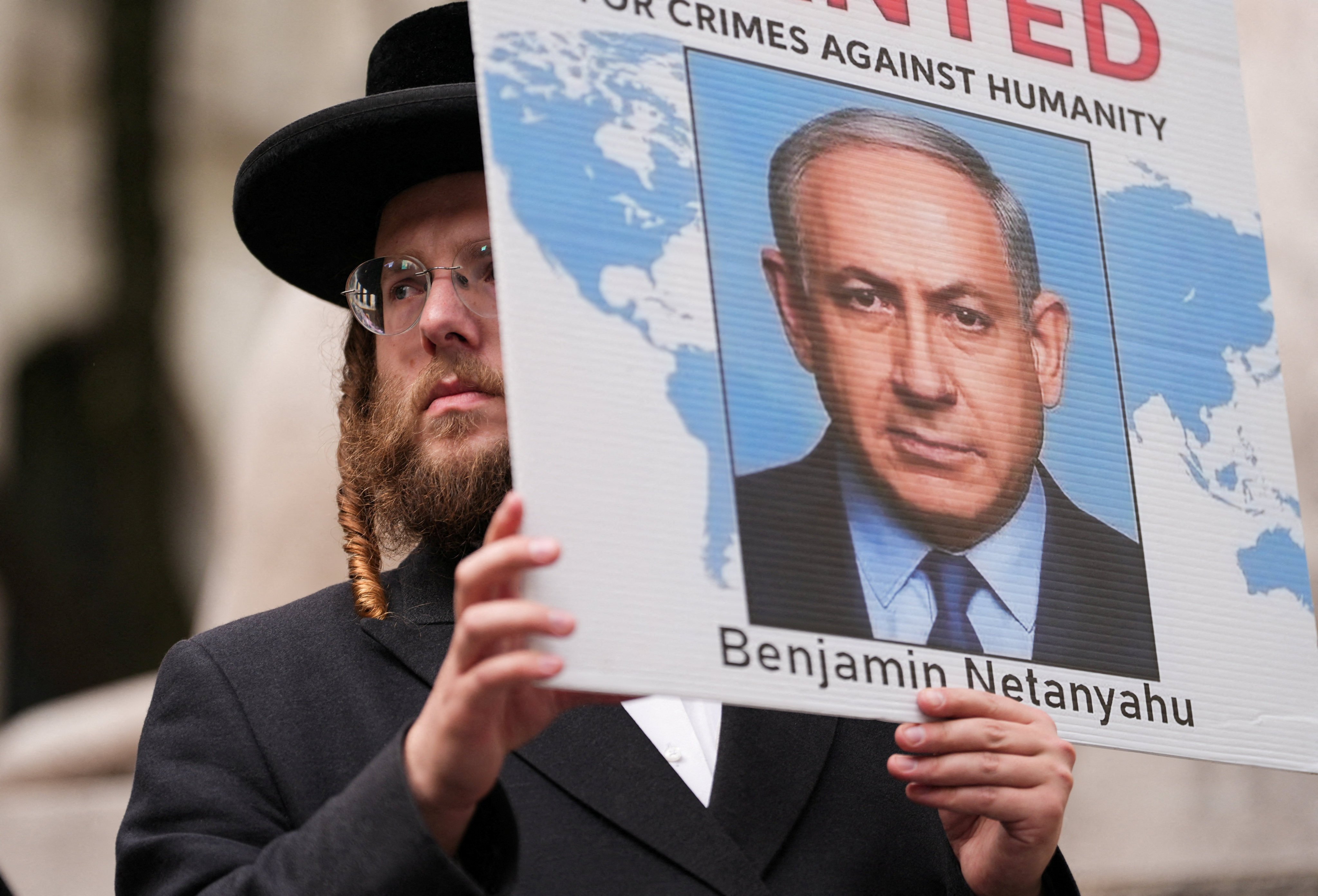 A person displays a sign as demonstrators protest. Photo: Reuters