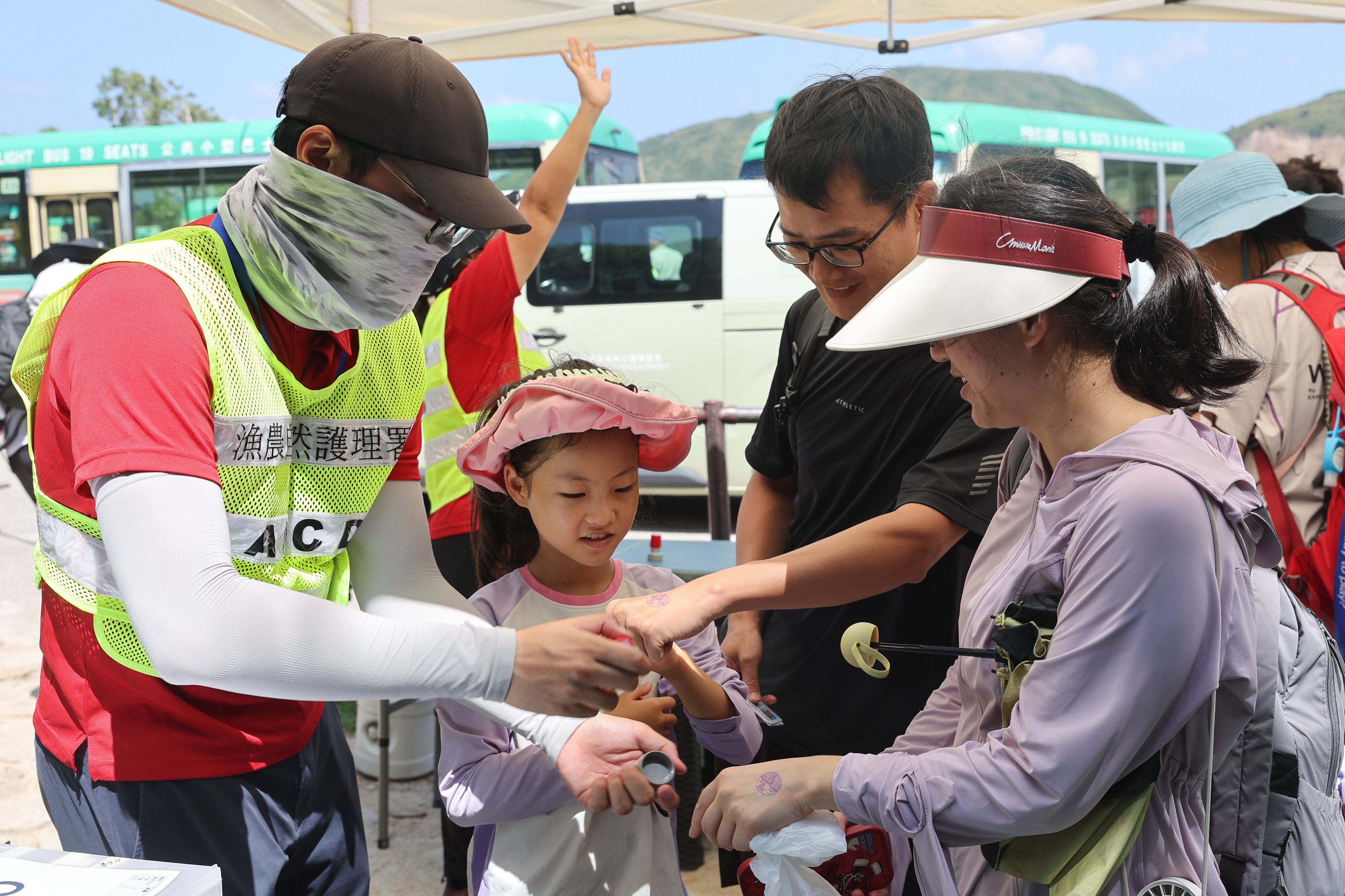 Tourists getting their hands stamped for entry after using the Po Pin Chau booking system on Friday. Photo: Edmond So
