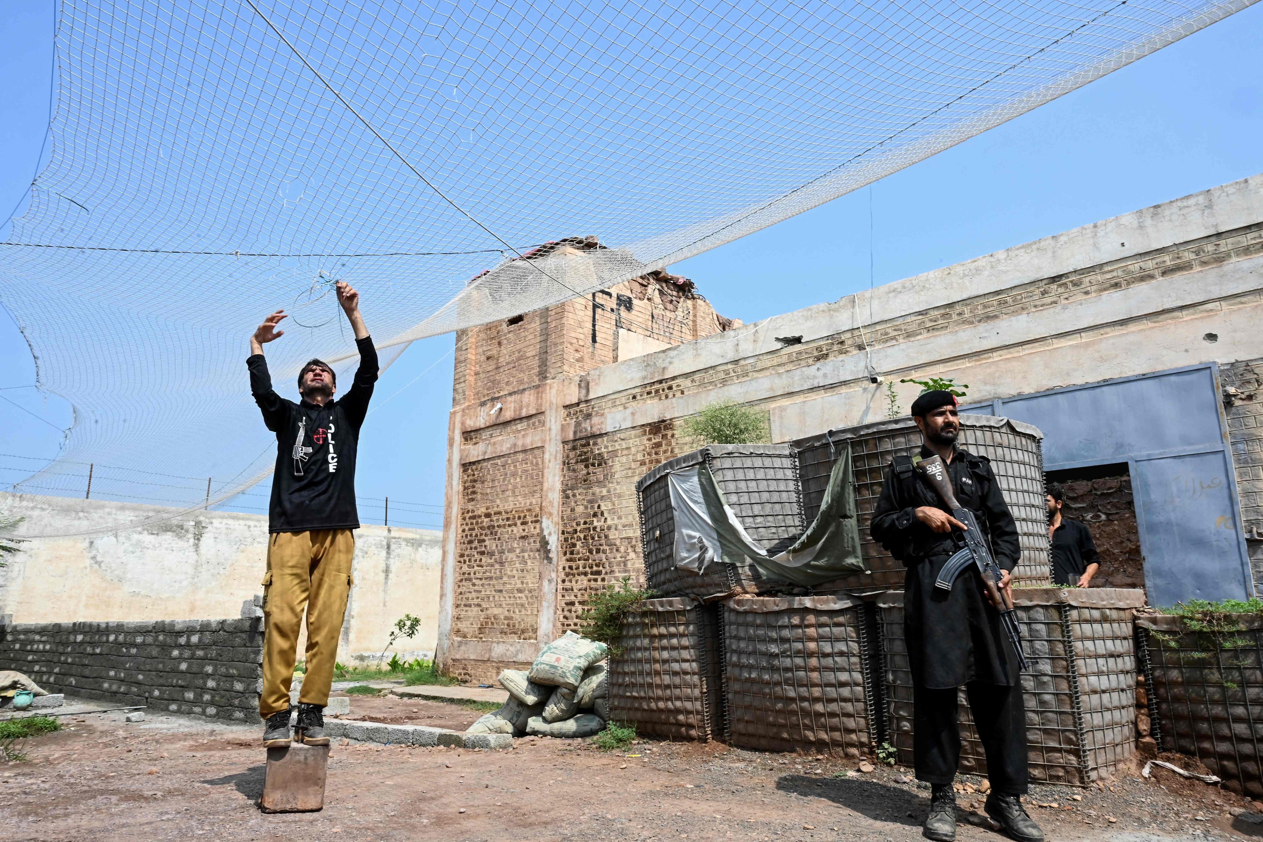 Security personnel fortify a police post with Ukraine-style mesh barriers, as a new line of defence against militant drone and aerial attacks, at Bara in Pakistan’s Khyber Pakhtunkhwa province, in August. Photo: AFP