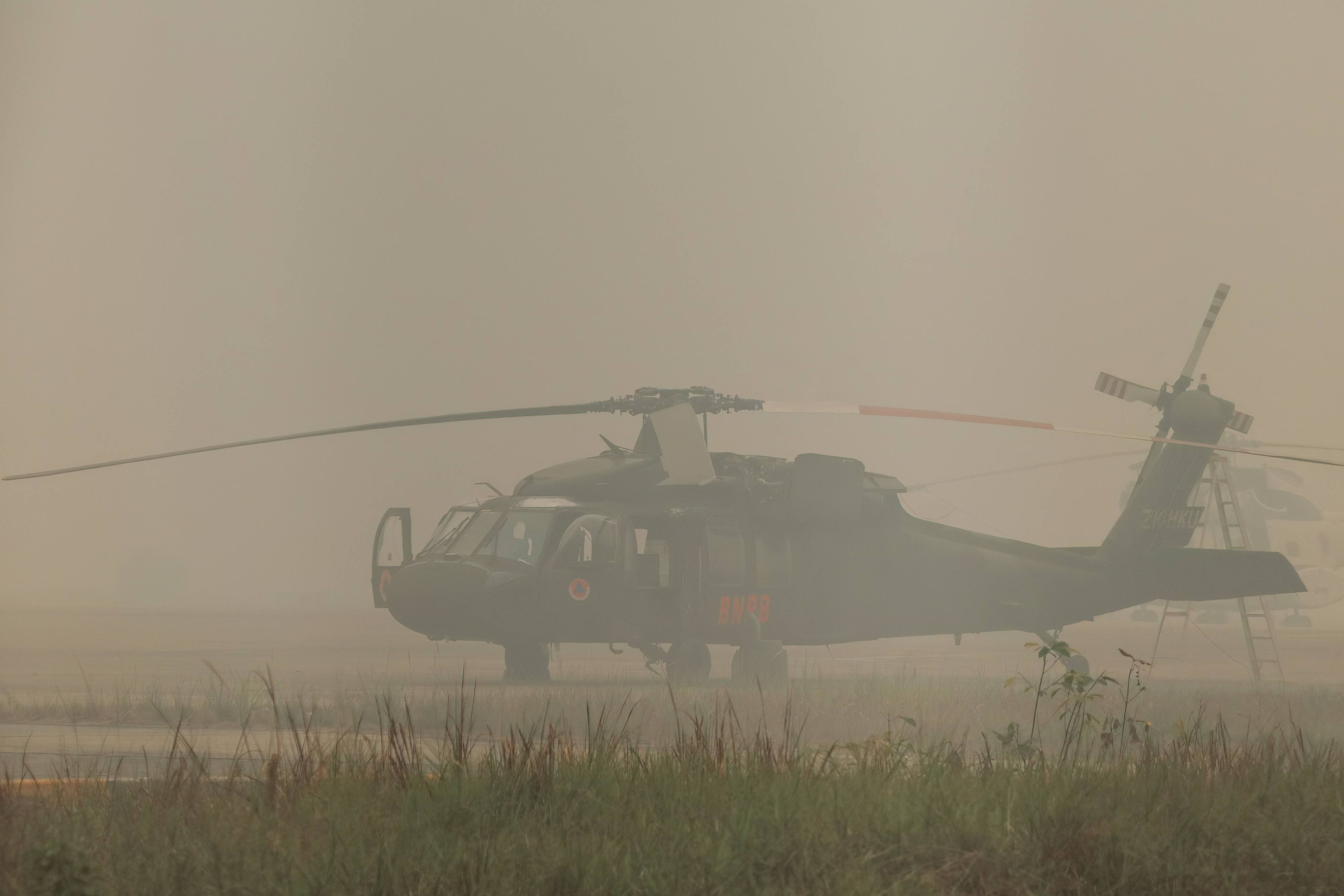 A firefighting helicopter sits on the tarmac enveloped in haze at an airport in Palangkaraya, Central Kalimantan, Indonesia, on Thursday. Photo: AFP