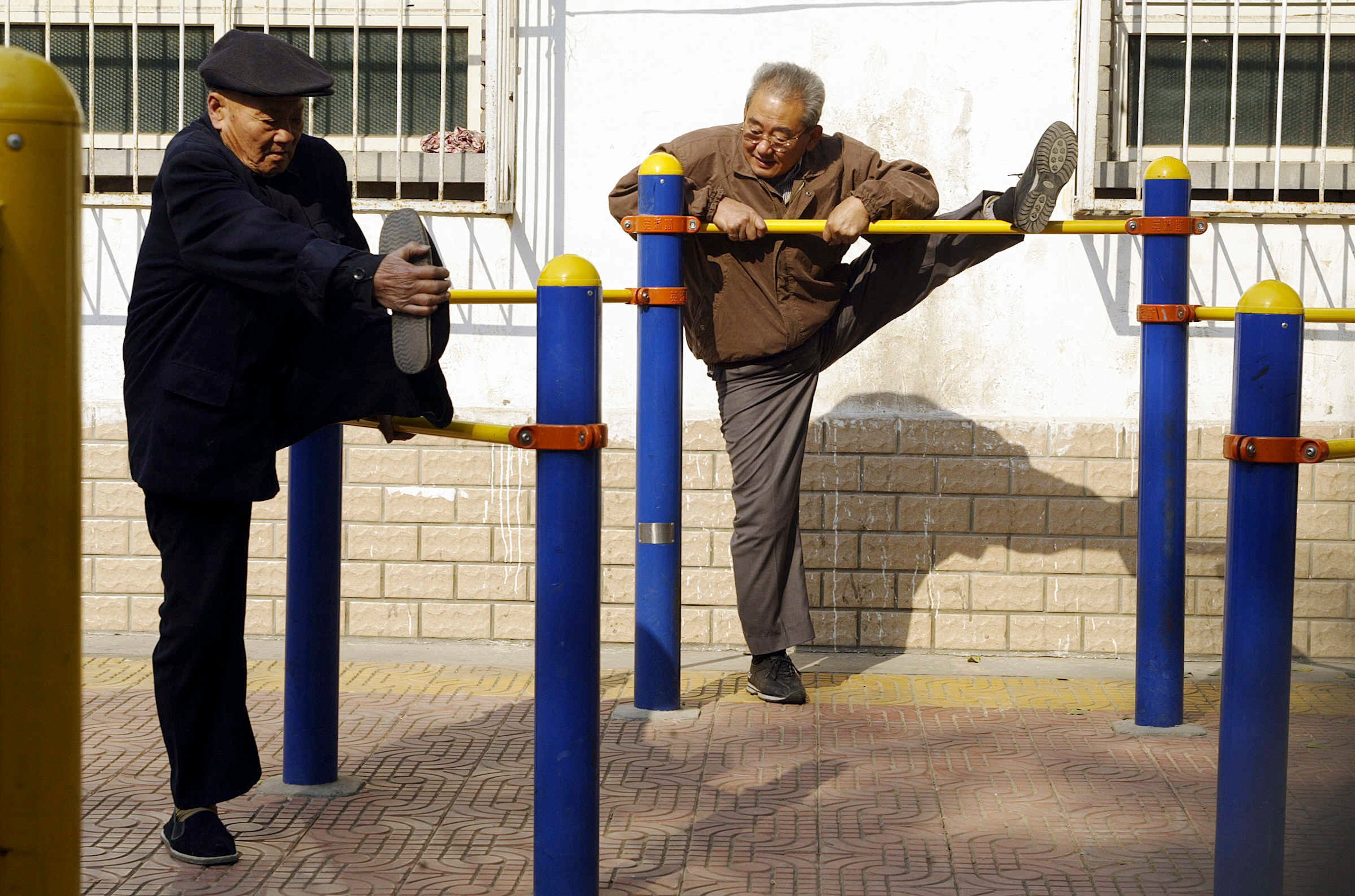 Two elderly Beijing residents stretch at an exercise park. Photo: AFP/File photo