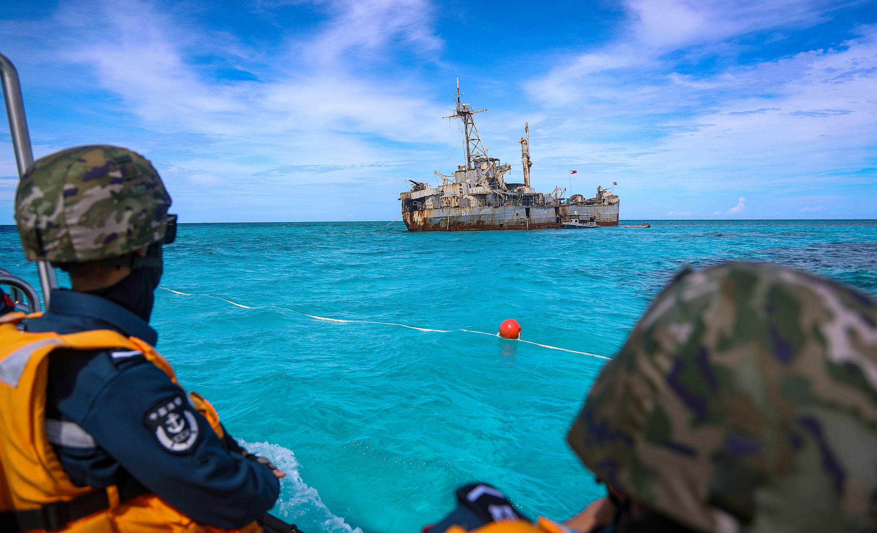 China Coast Guard personnel watch a Philippine ship near Second Thomas Shoal in the South China Sea. Beijing and Manila have competing maritime claims over the atoll and surrounding waters. Photo: Handout via Xinhua