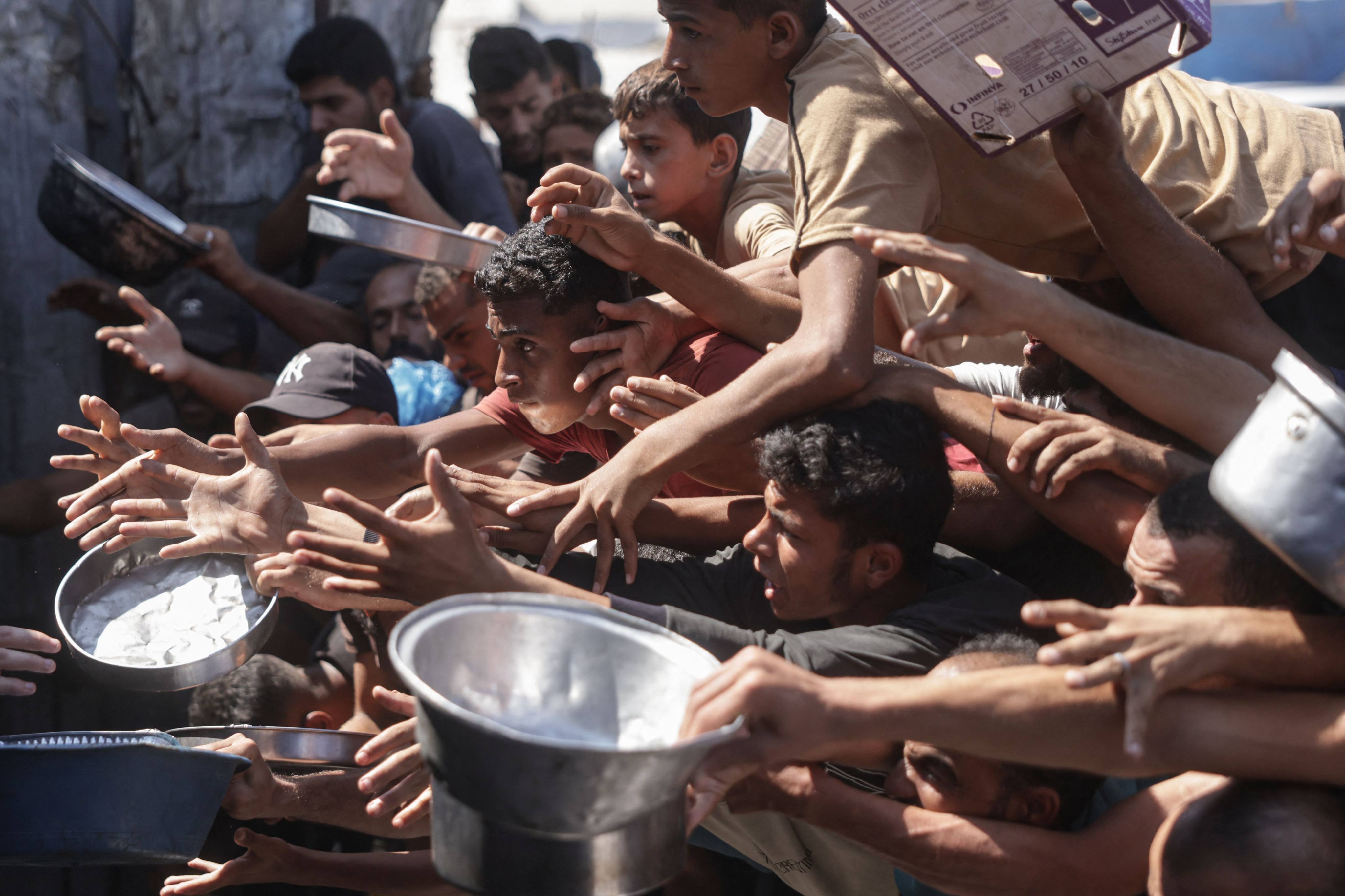 Displaced Palestinians gather to receive meals distributed by a charity kitchen in Khan Younis, southern Gaza Strip, on Friday. Photo: AFP