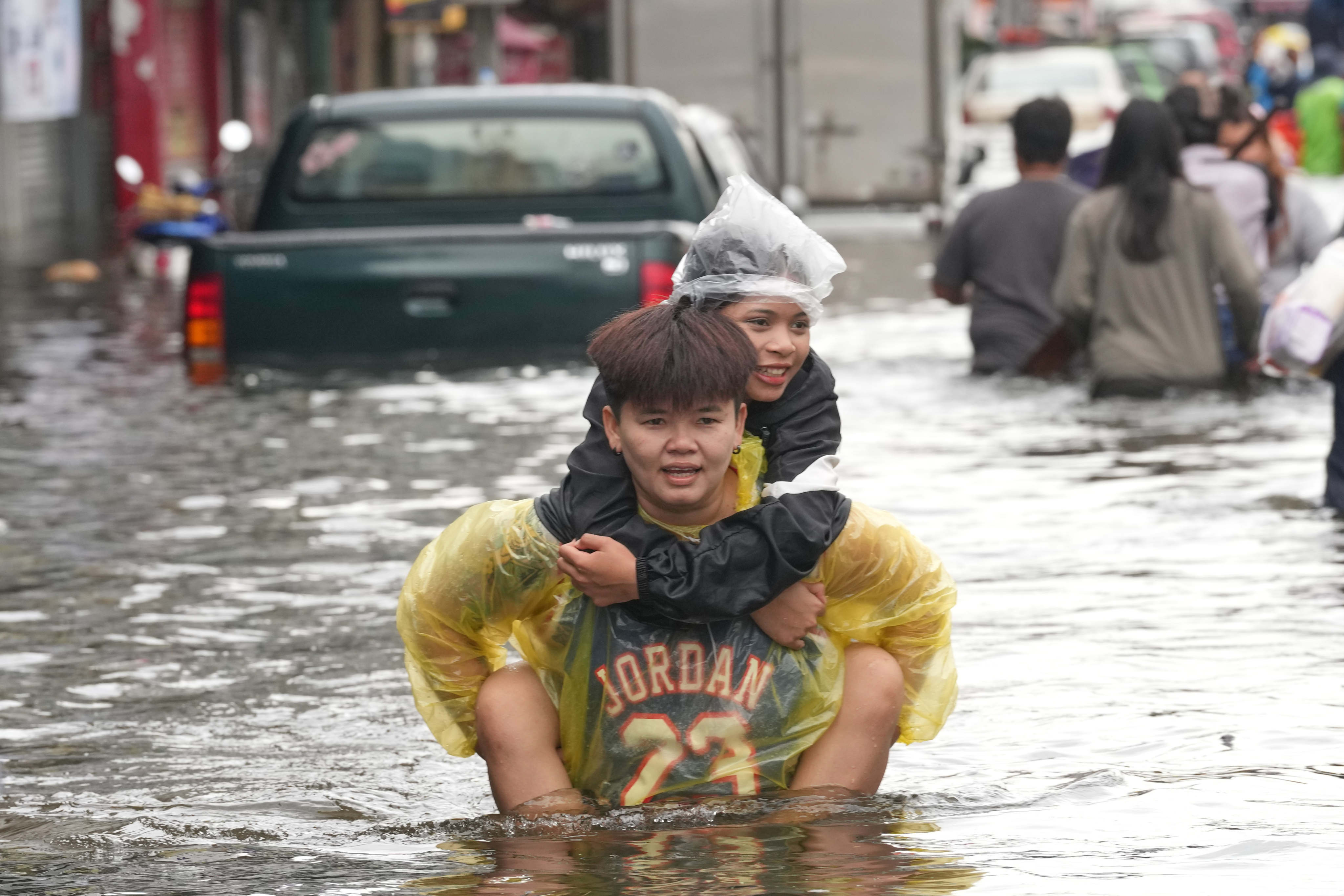 People wade through a flooded street after a heavy rain in Bangkok, Thailand, on Monday. Photo: AP