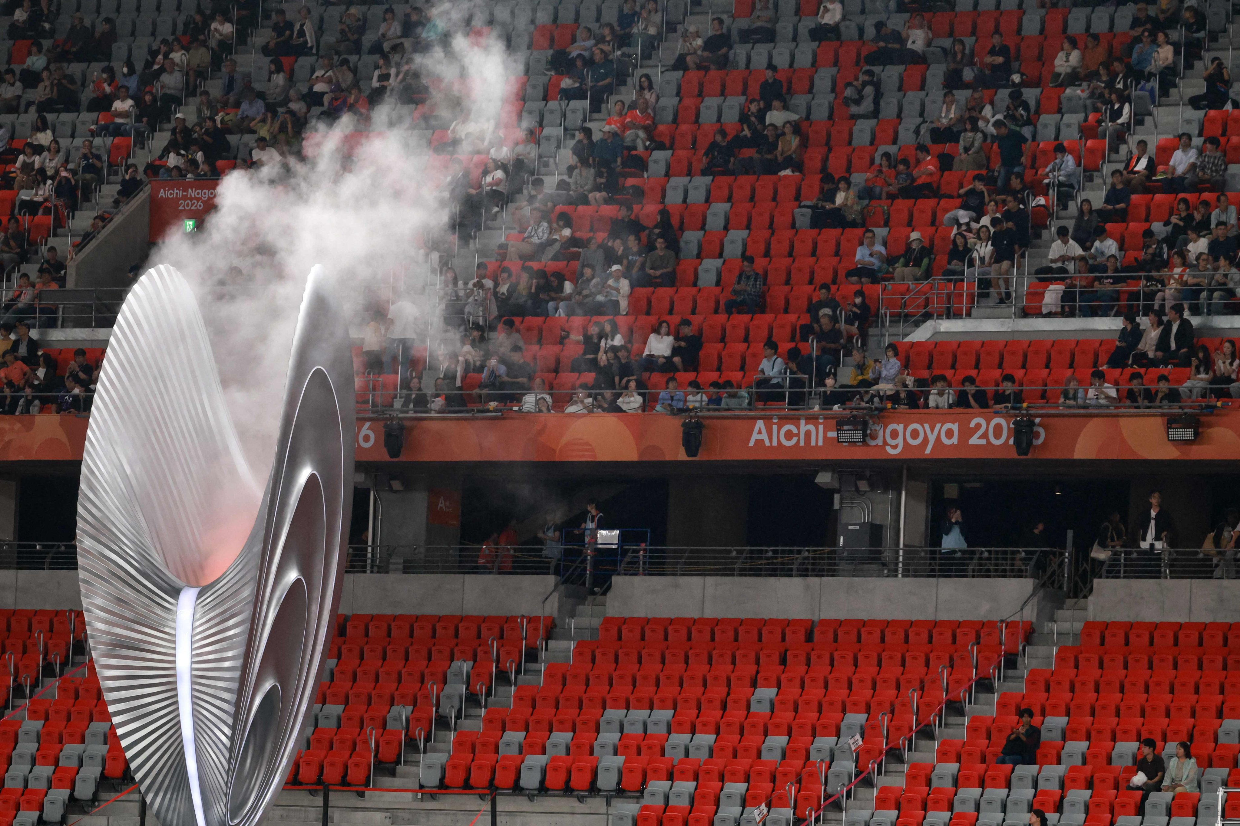 Sparse crowds of spectators watching the athletics programme  on Sunday as the Asian Games cauldron is seen in the foreground. Photo: AFP