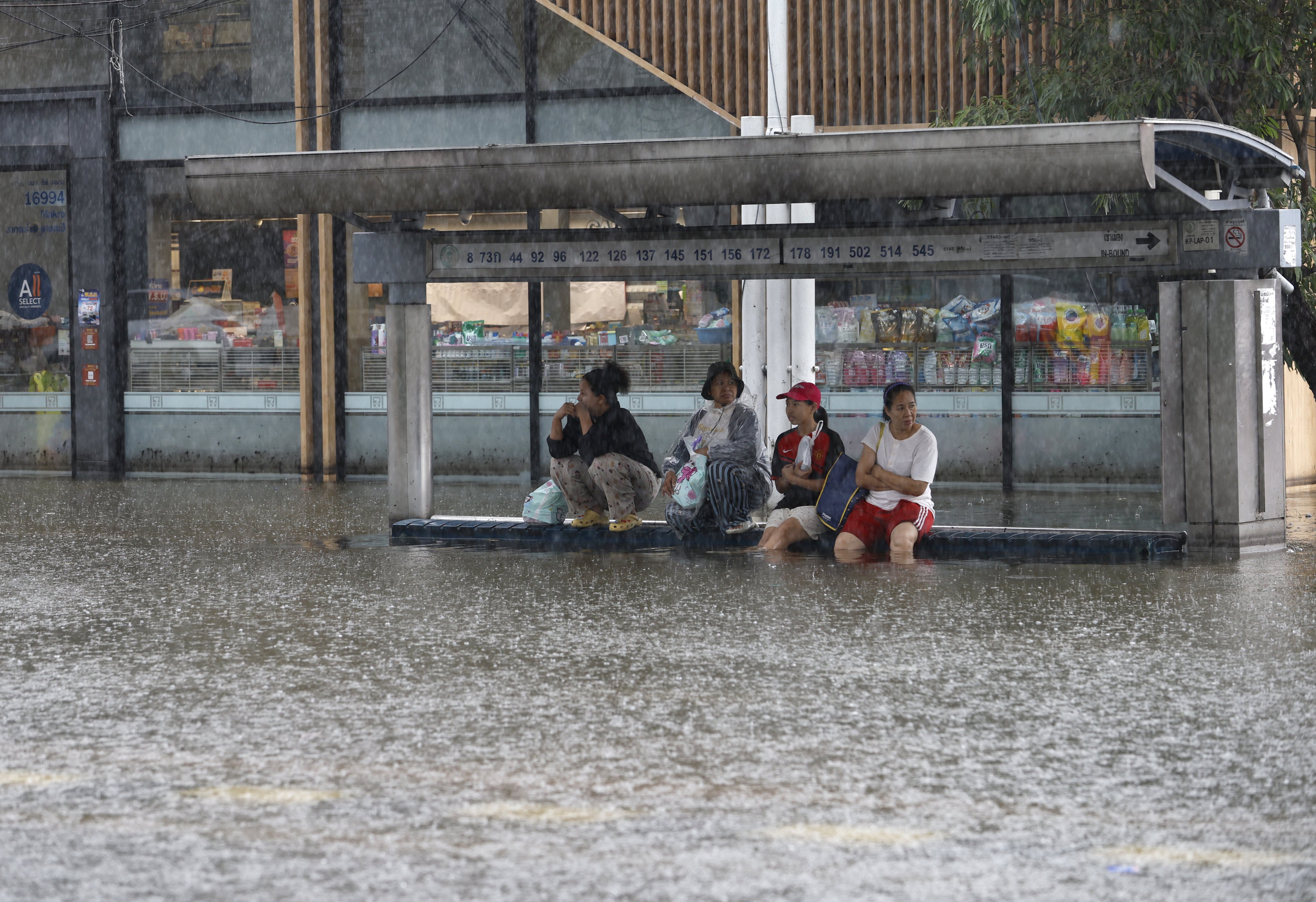 Thai residents wait for a truck for transport during a downpour in the flooded Bang Kapi district of Bangkok, Thailand, on Monday. Photo: EPA
