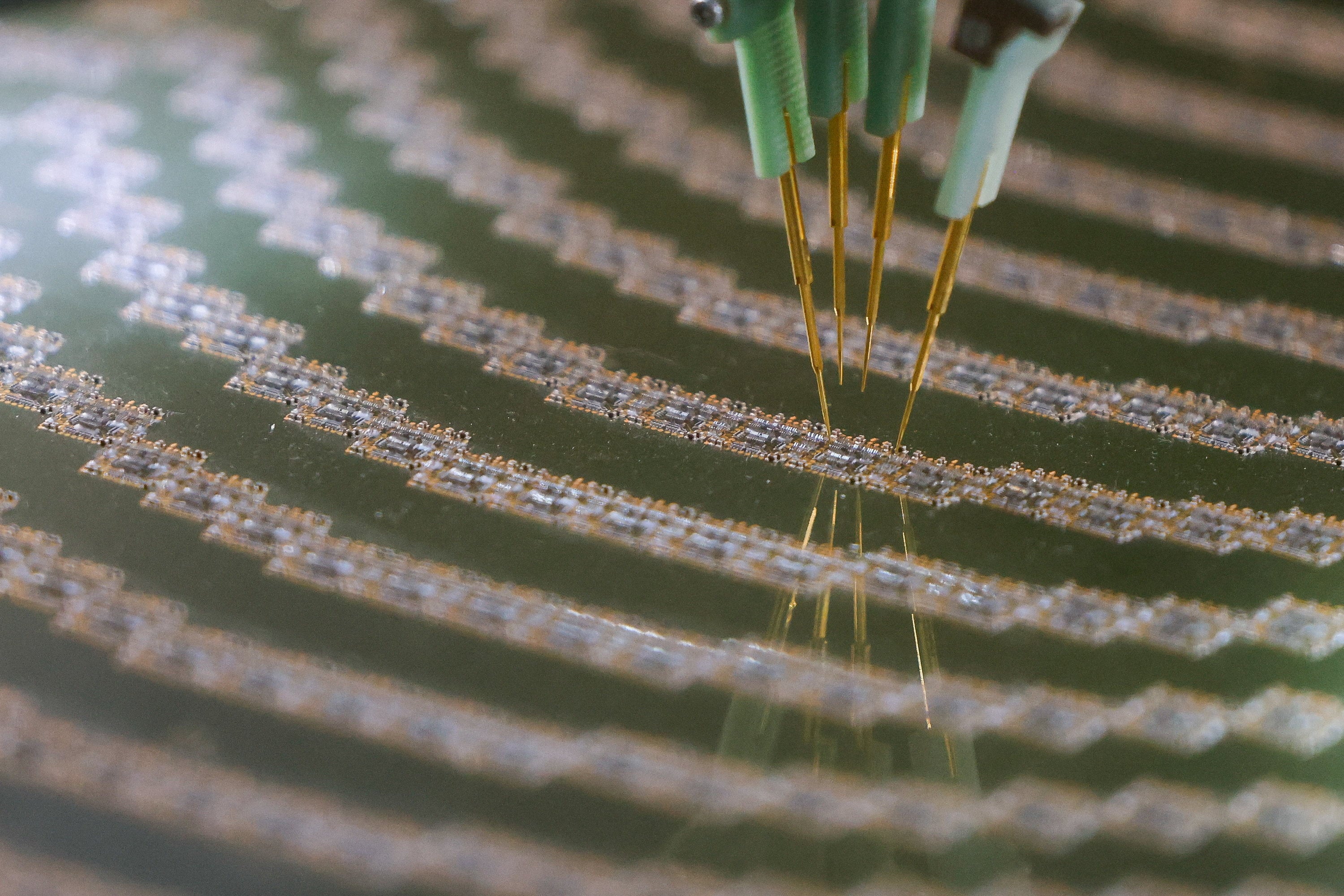 Probe needles test semiconductor devices on a wafer during a trade show. Photo: Reuters