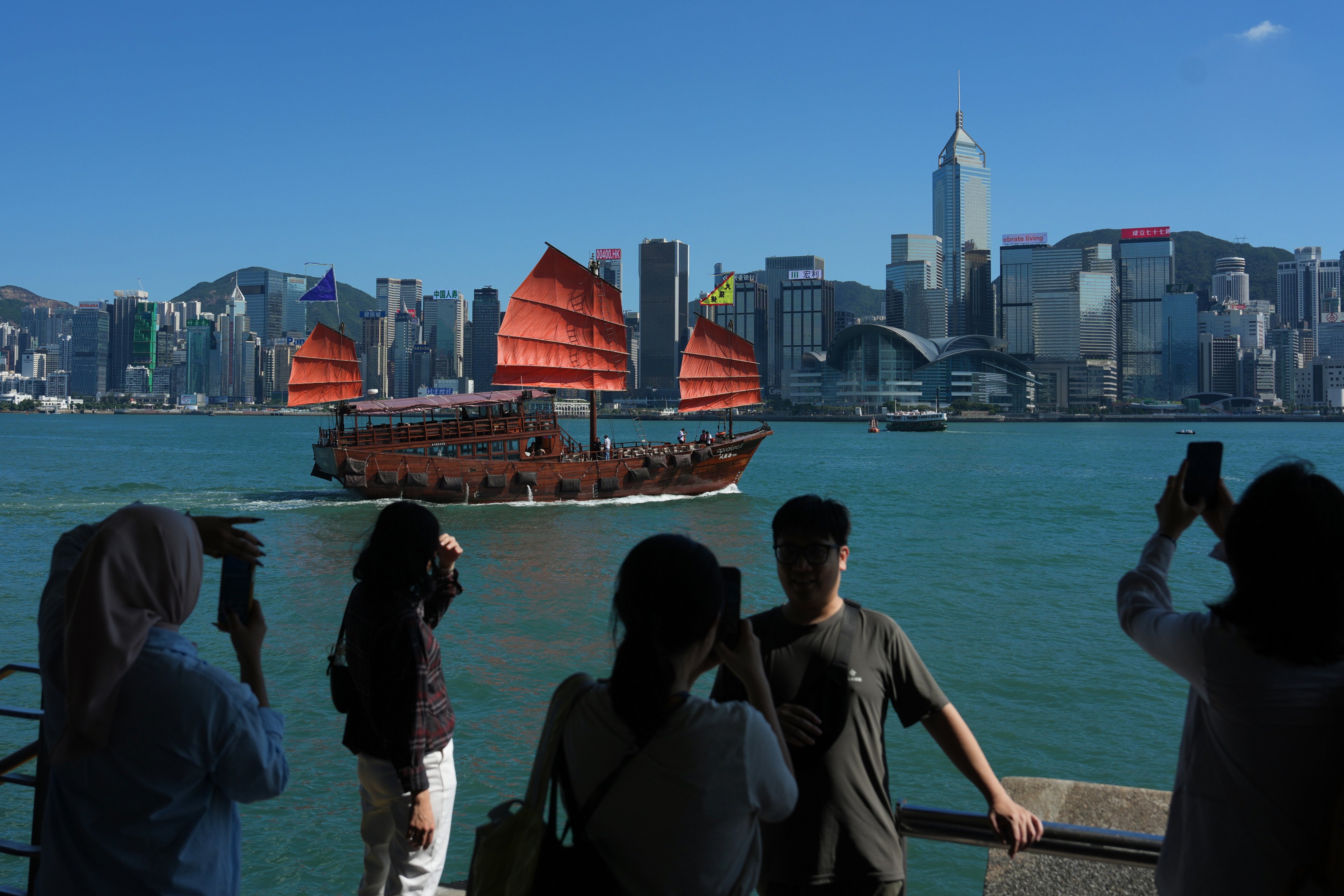 Tourists take pictures at the waterfront of Victoria Harbour in Tsim Sha Tsui. Photo: Kit Lai