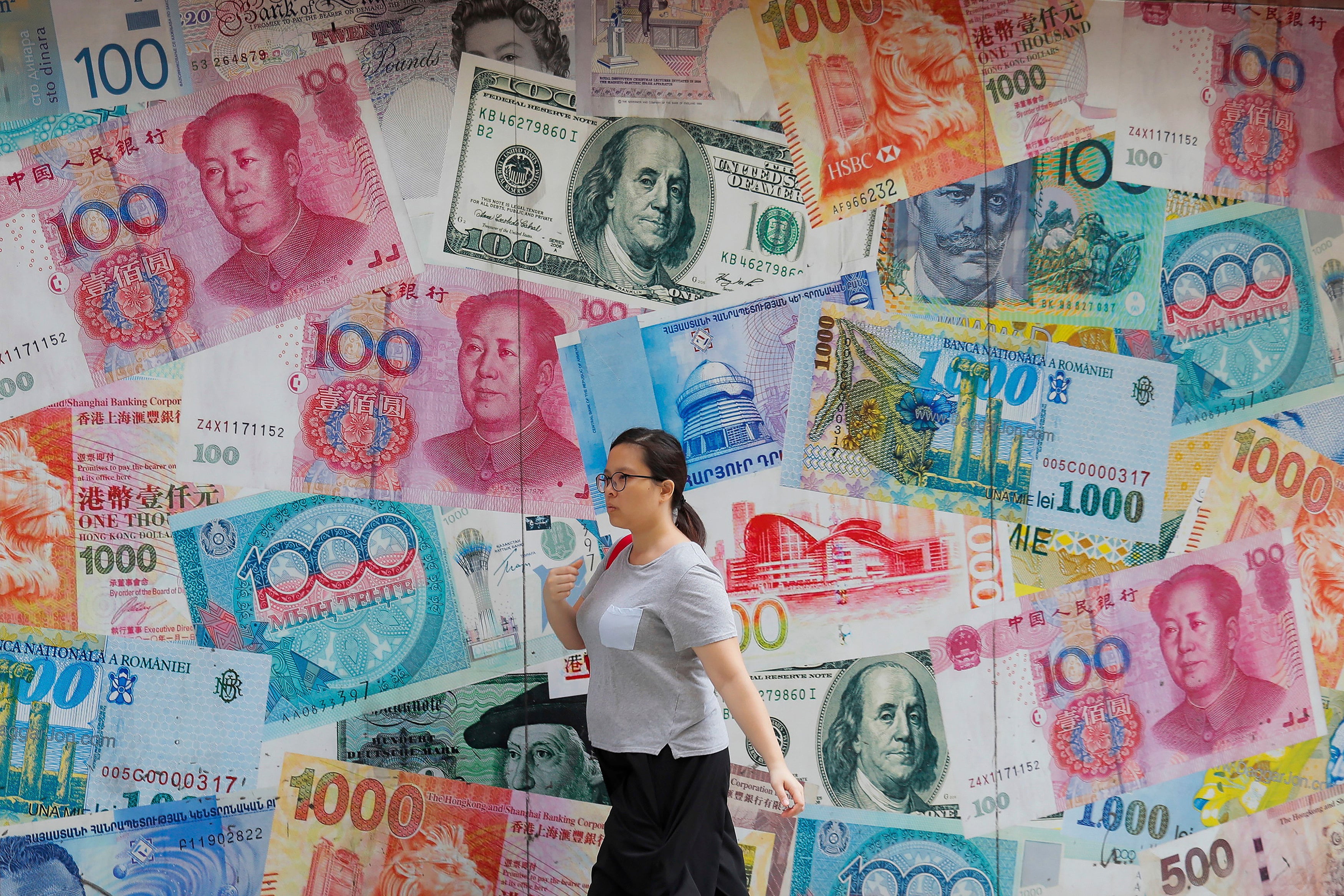 A woman walks past a money exchange shop decorated with banknotes from different countries in Central, Hong Kong, in 2019. Financial de-dollarisation may be less about the end of dollar dominance than about the gradual expansion of choice around it. Photo: AP