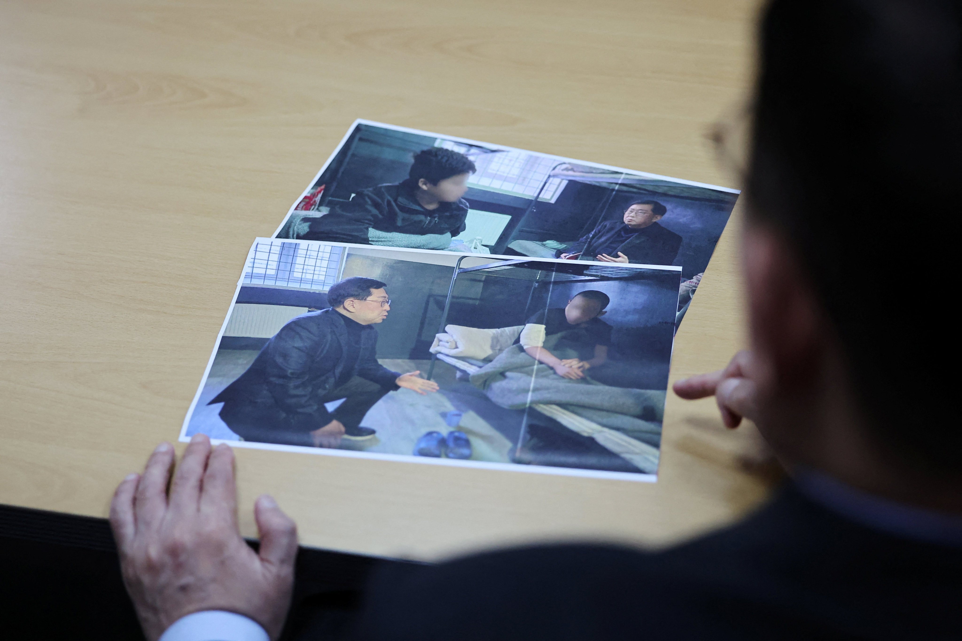 A South Korean lawmaker shows pictures of North Korean POWs transferred from Ukraine to South Korea at the National Assembly in Seoul on Monday. Photo: Reuters