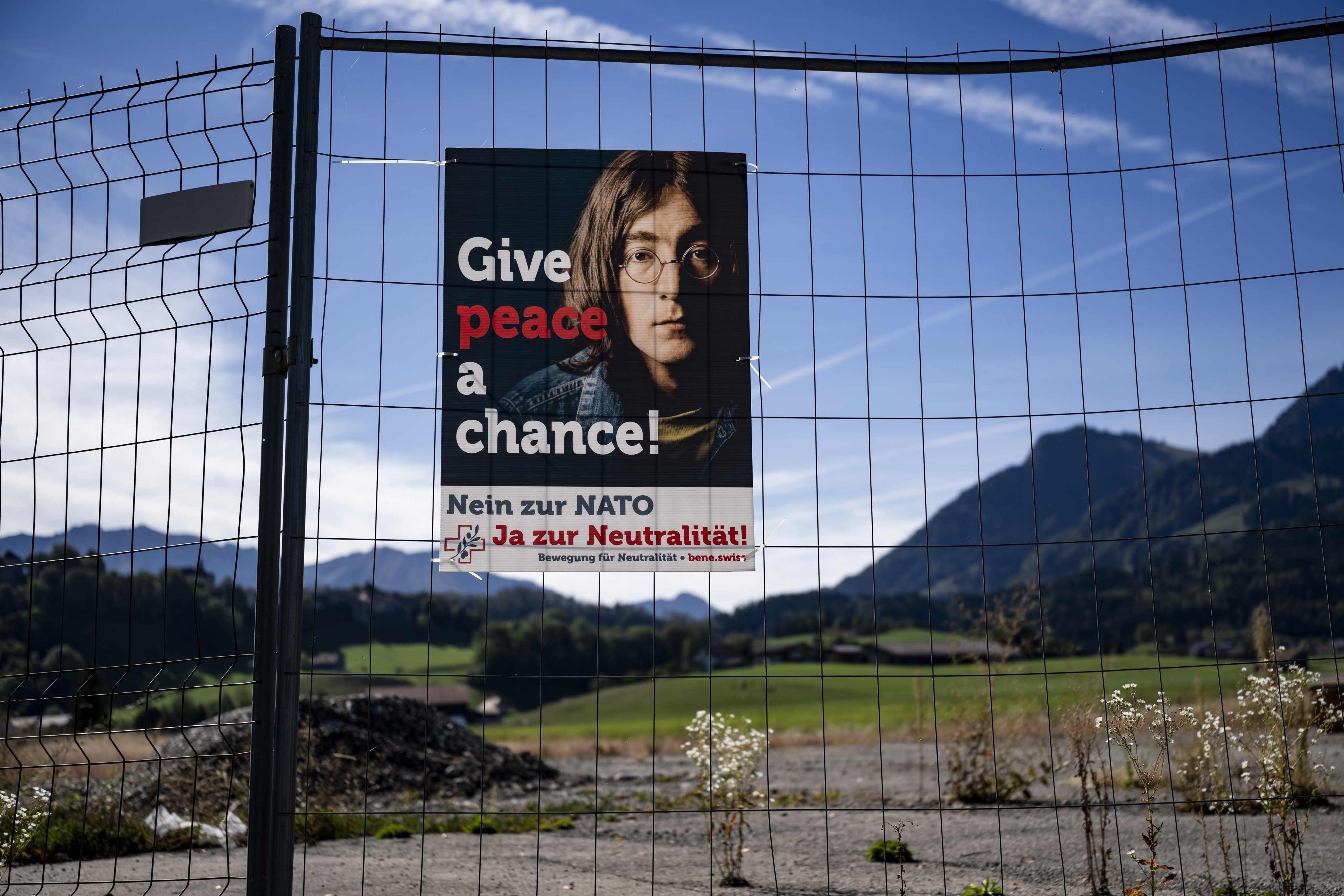 A campaign poster with the late musician John Lennon’s image hangs on a fence in Epagny, near Fribourg, Switzerland on Friday ahead of Sunday’s vote on the “Safeguard Swiss neutrality” Initiative. Photo: EPA