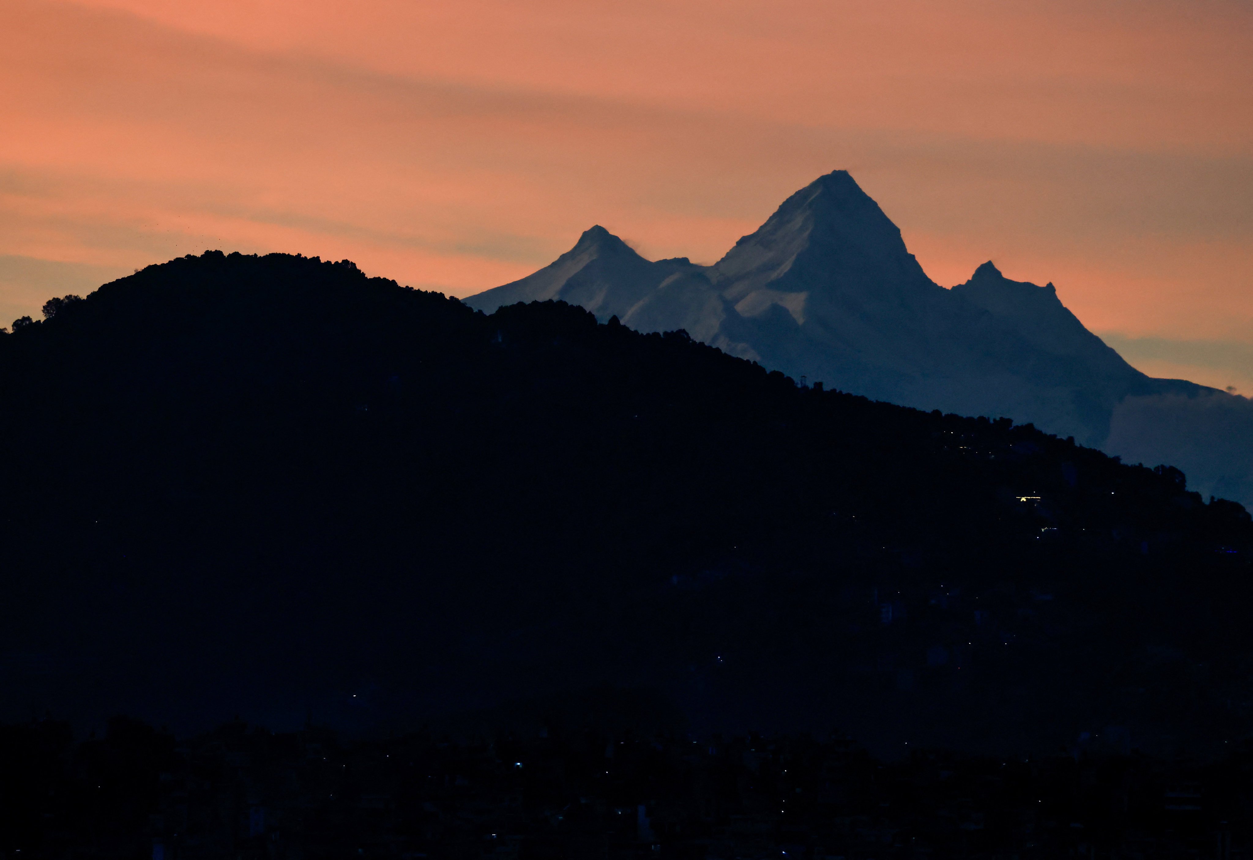 A snowcapped mountain range emerges over the valley after the rain clouds clear in Kathmandu, Nepal, on Sunday. Photo: Reuters