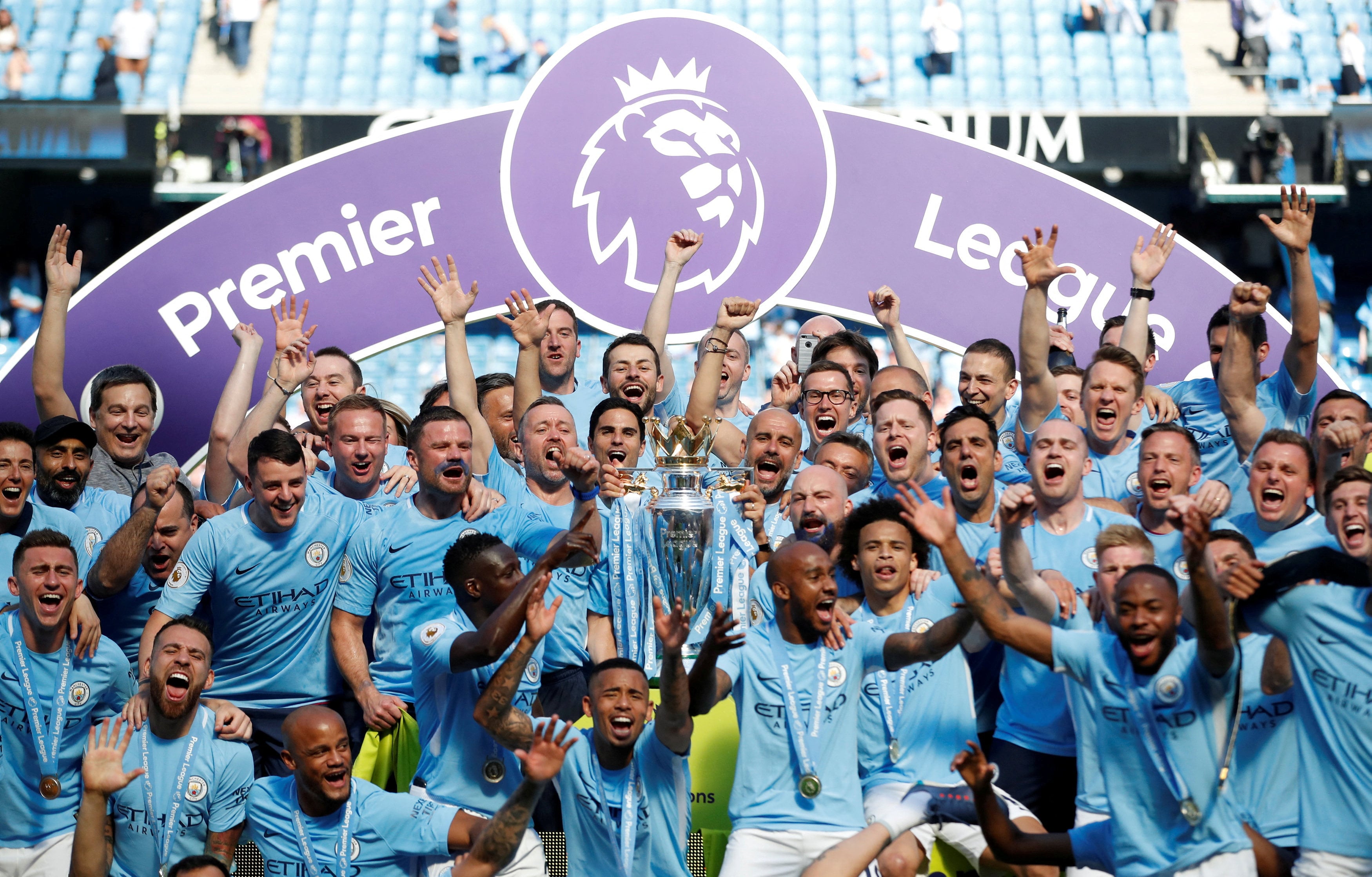 Manchester City manager Pep Guardiola celebrates with the trophy, players and staff after winning the Premier League title in 2018. Photo: Reuters