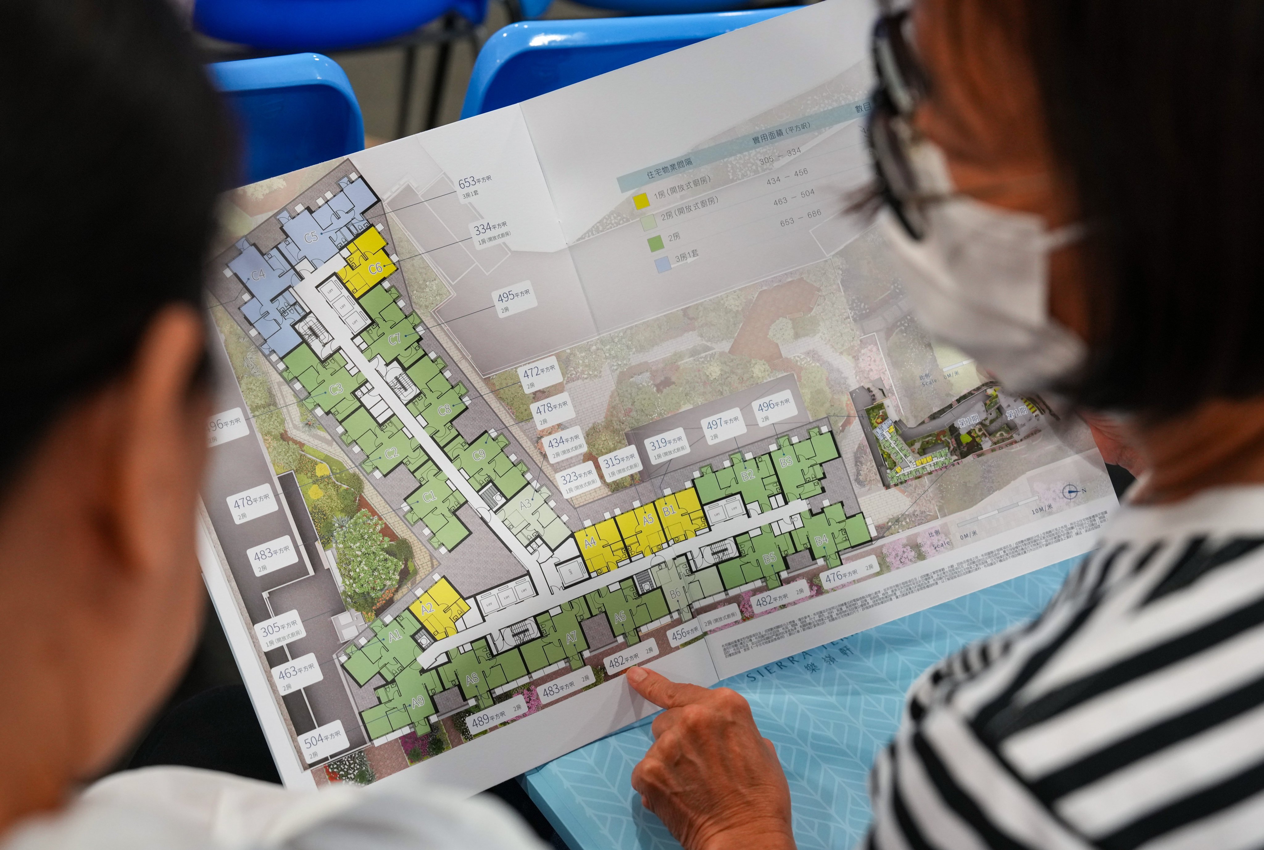 Residents look over a layout for one of the available subsidised housing estates. Photo: Kit Lai