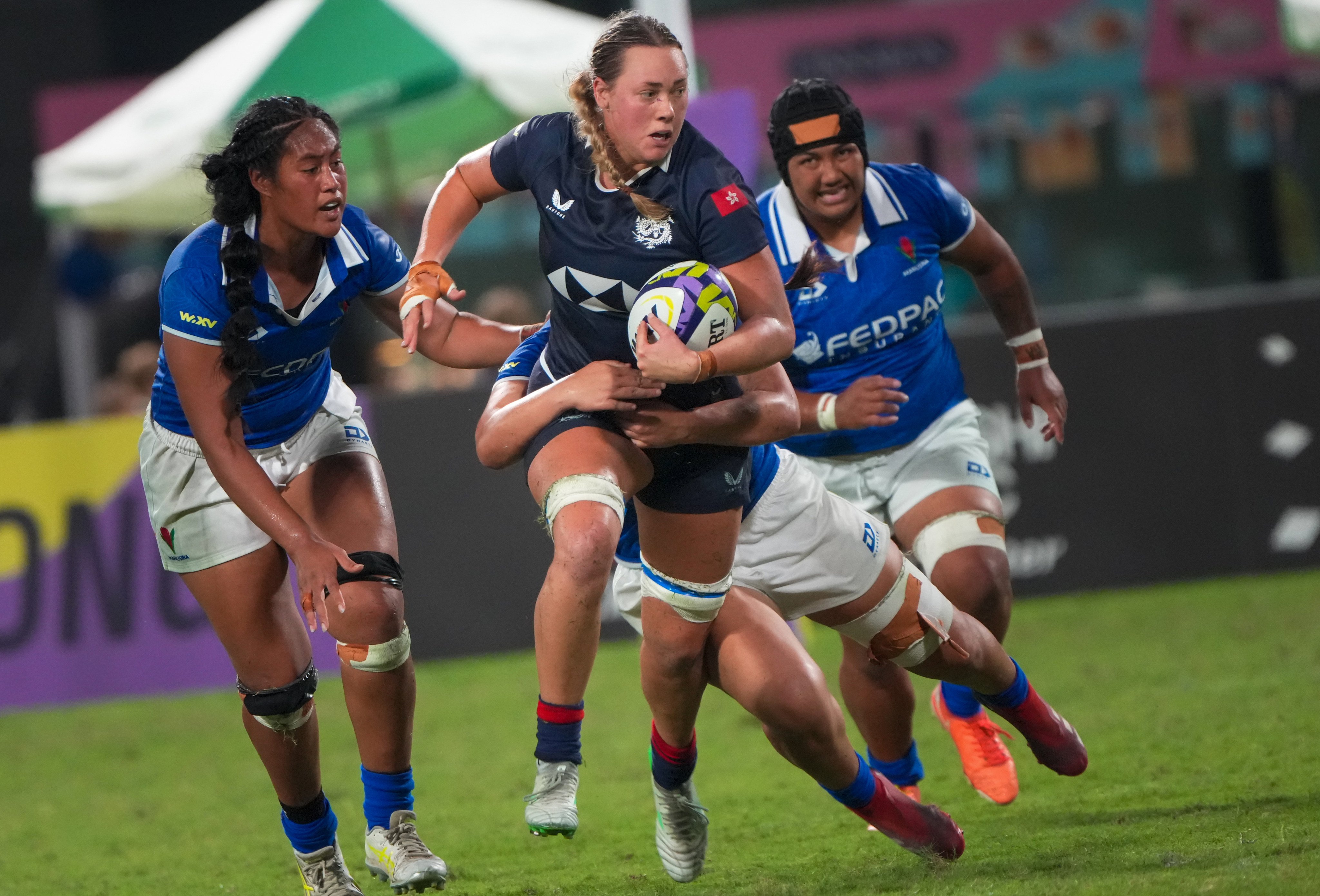Grace Hood tries to escape the attentions of three Samoan opponents during Hong Kong’s 34-17 defeat on Saturday. Dickson Lee