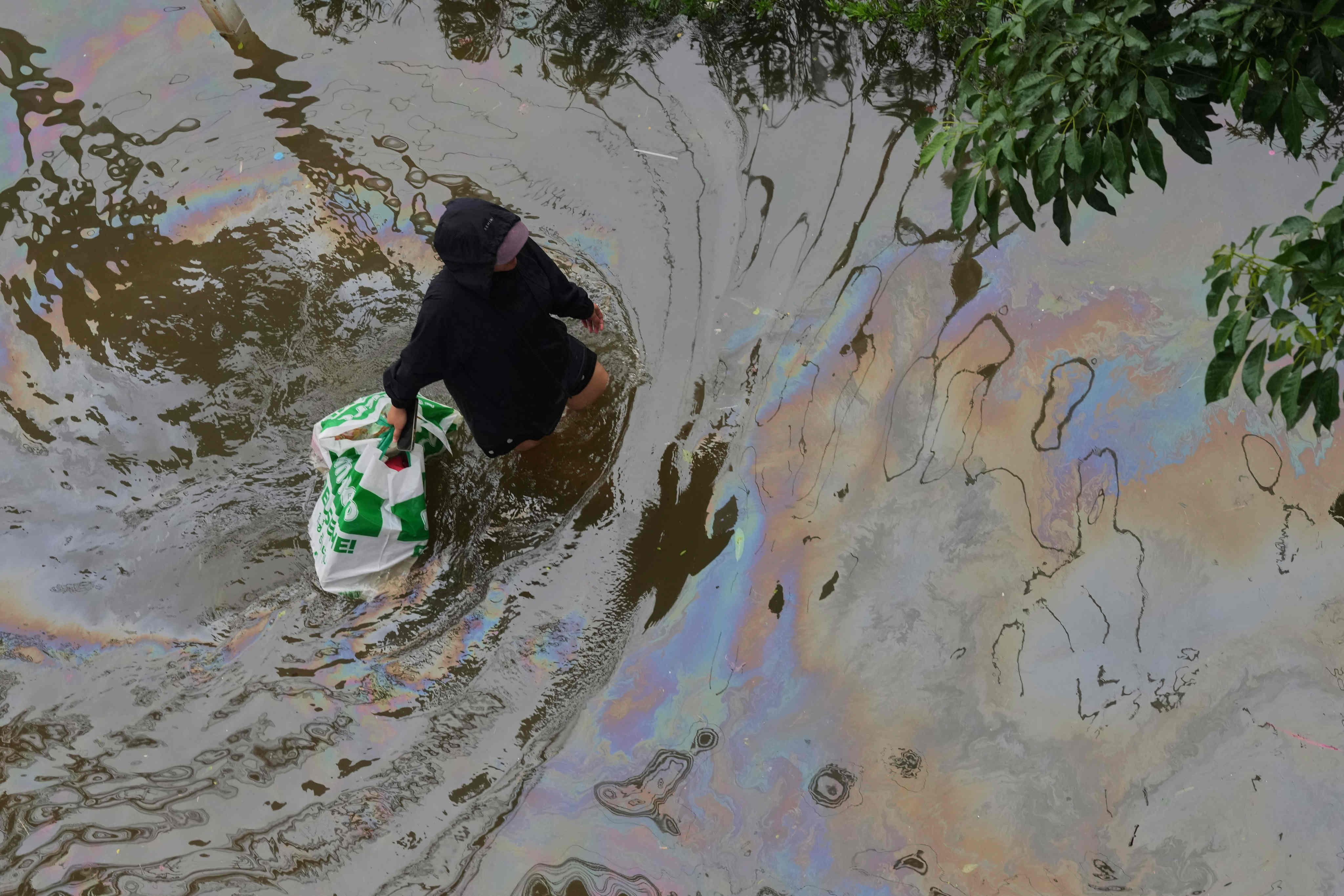 A woman wades through floodwaters after heavy rain in Bangkok on Sunday. Photo: AP