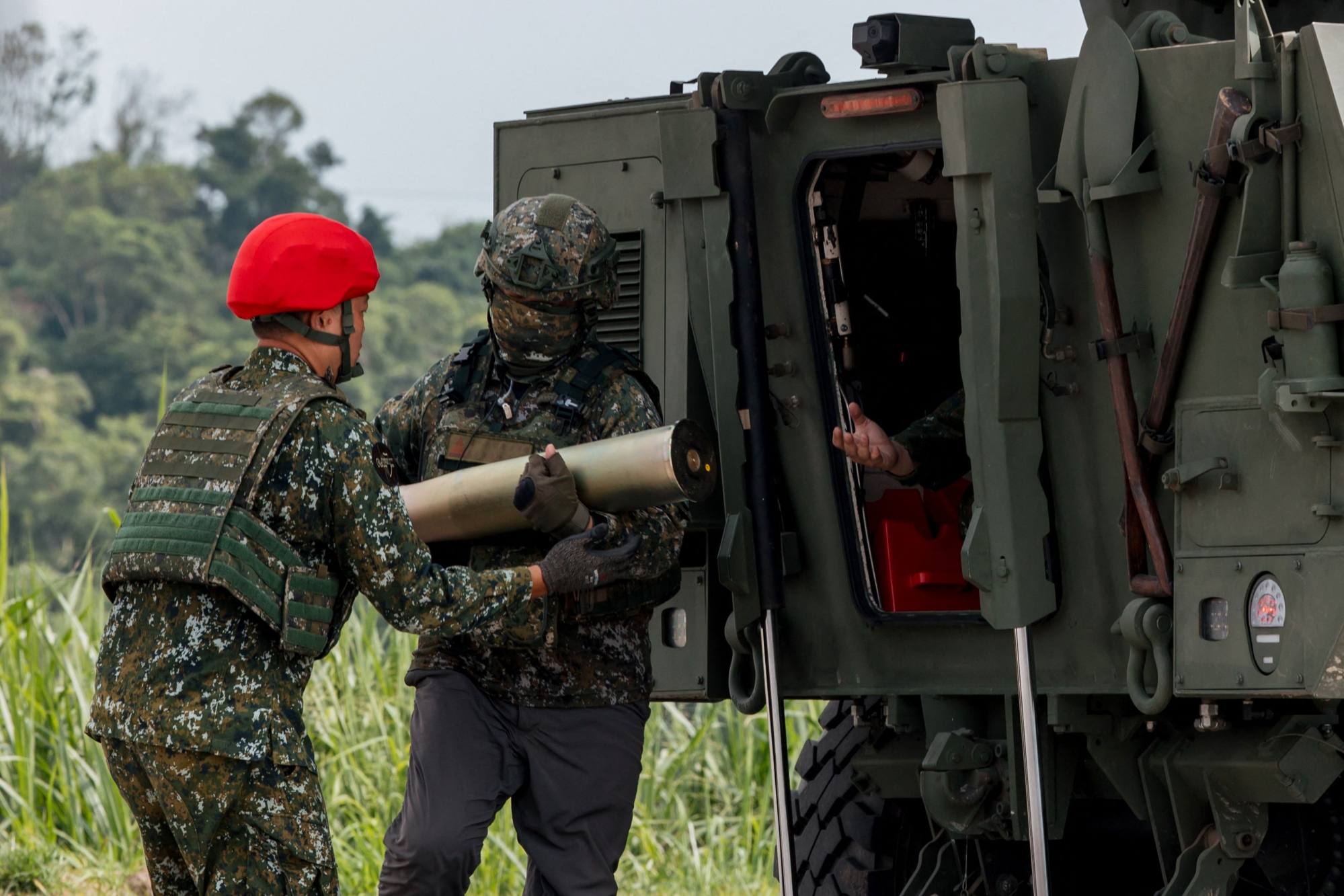 Taiwan military personnel load ammunition into a domestically developed 105mm wheeled armoured vehicle during a live-fire demonstration in Tainan on September 23. Photo: AFP