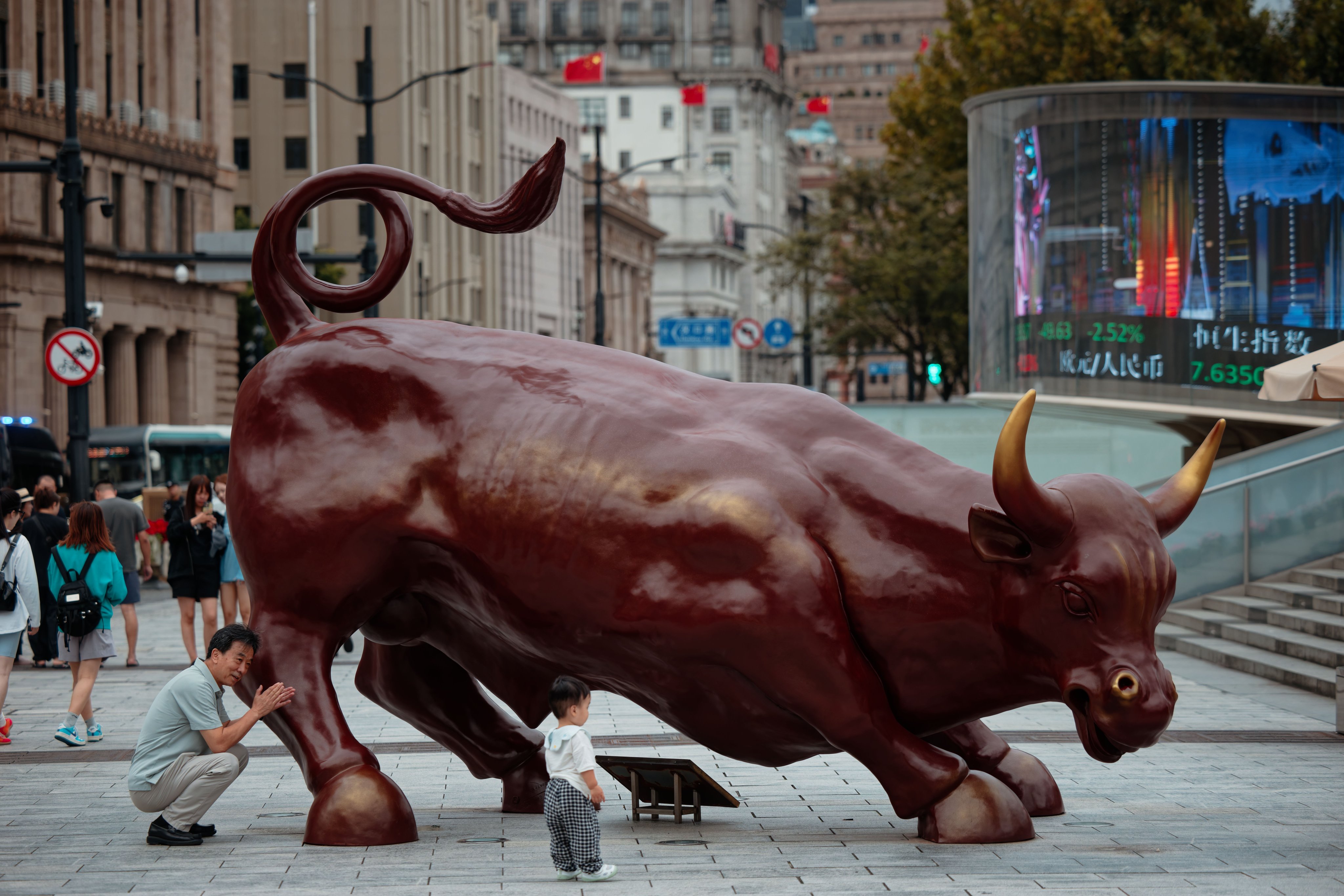 People walk past a bull statue in Shanghai, China. Photo: EPA