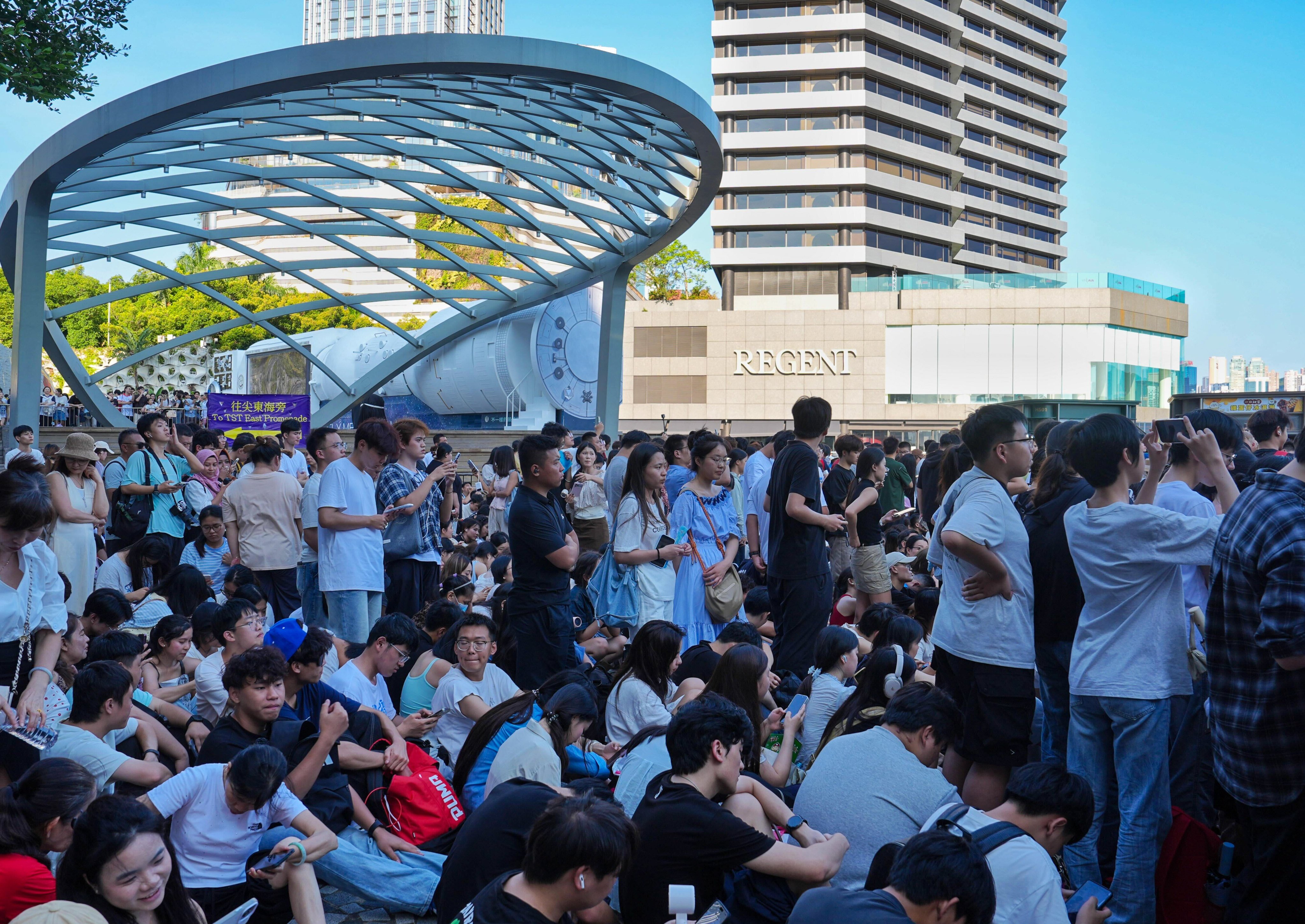 Spectators gather along Victoria Harbour hours before Hong Kong’s National Day fireworks display, braving the sweltering heat to secure a good view. Photo: Elson Li