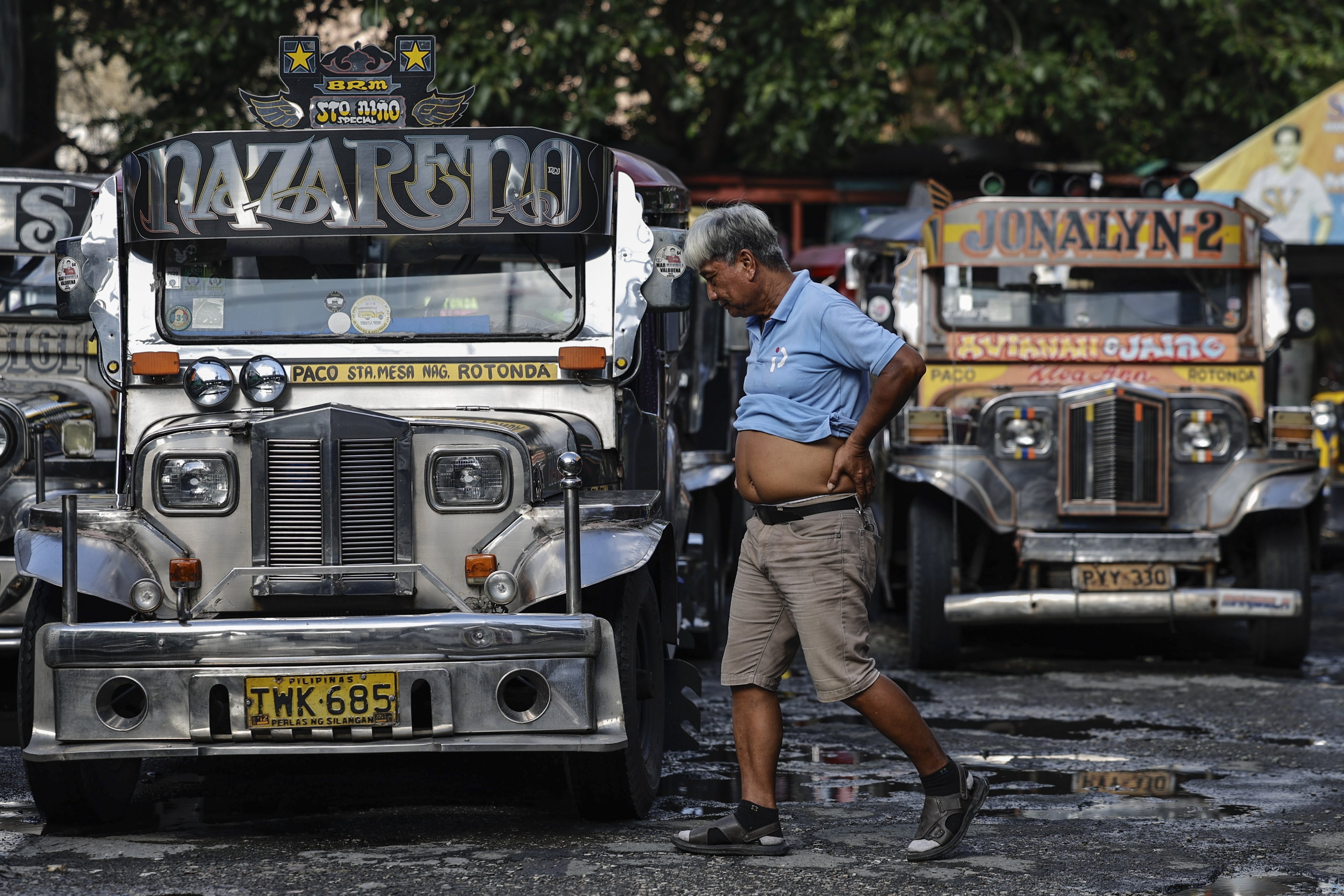 A driver walks past parked jeepneys that have not been operated due to a transport strike in Manila, the Philippines, on September 14. Photo: EPA