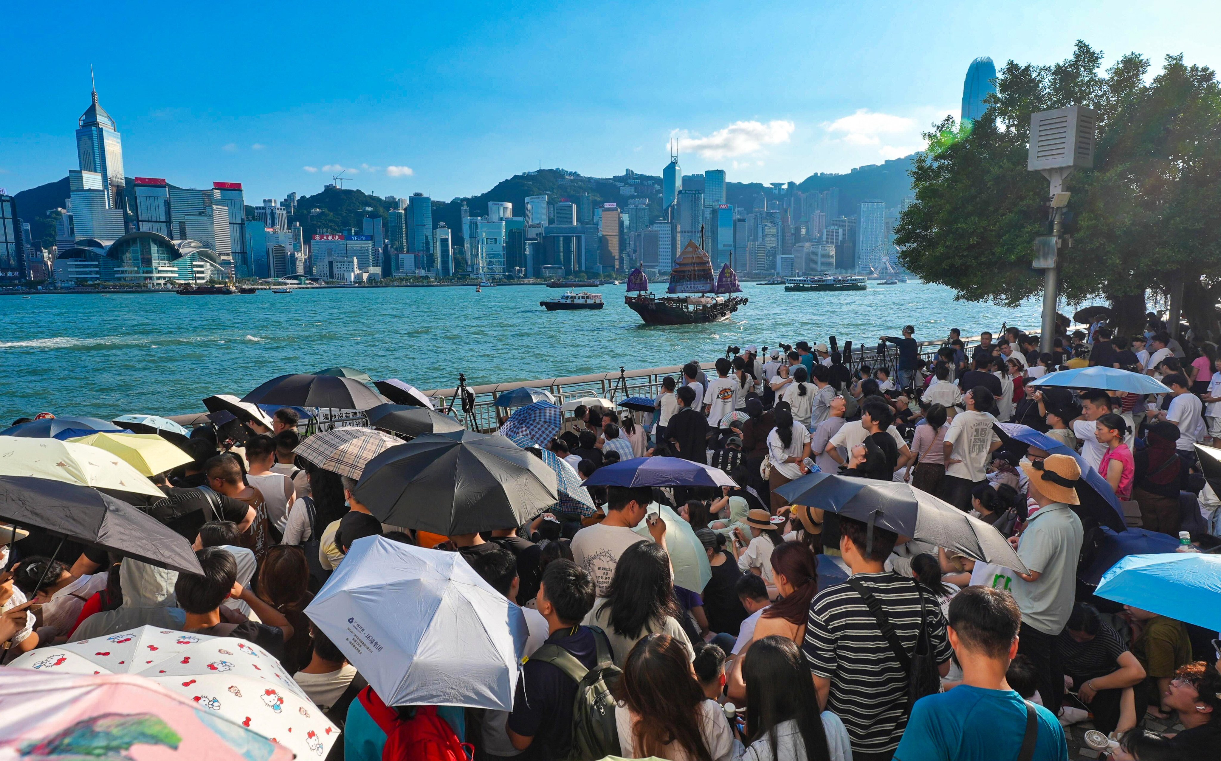 Spectators gather along Victoria Harbour hours before Hong Kong’s National Day fireworks display, braving the sweltering heat to secure a good view. Photo: Elson Li