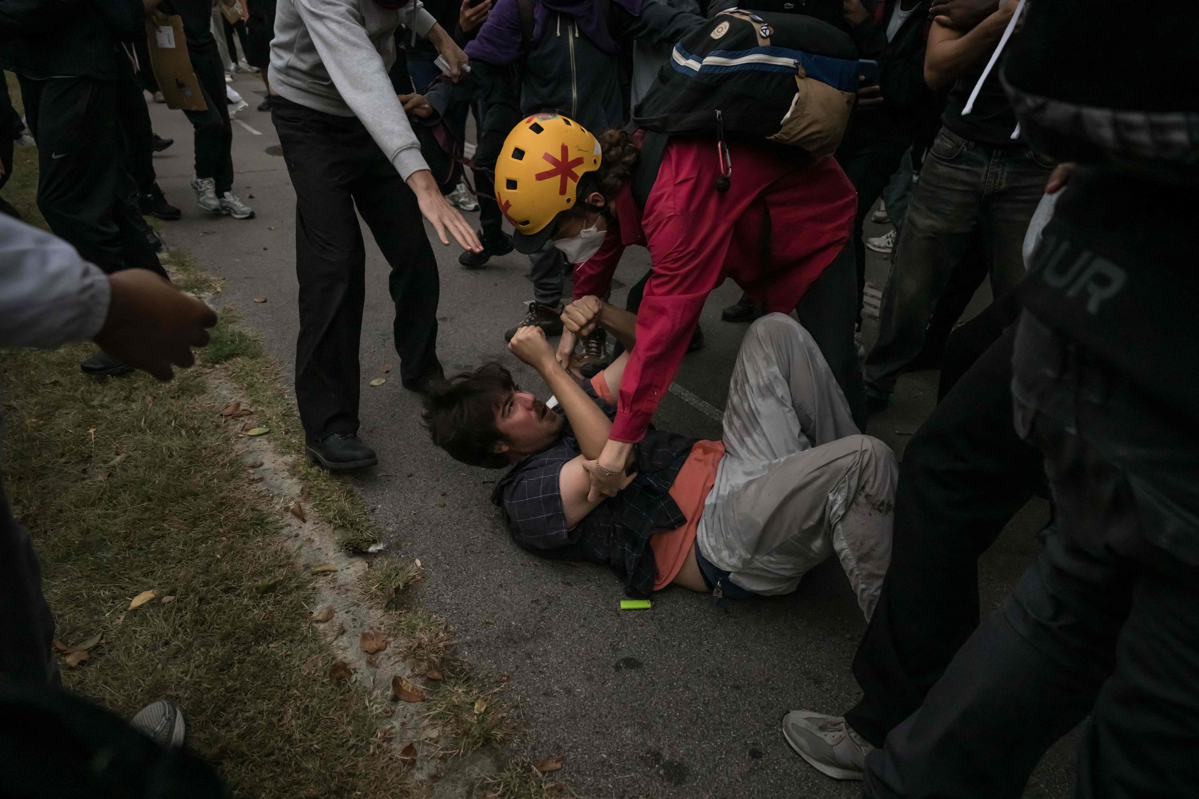 A man is helped after scuffling with students near the Lycee Deodat high school in Toulouse, southwestern France, on Thursday. Photo: AFP