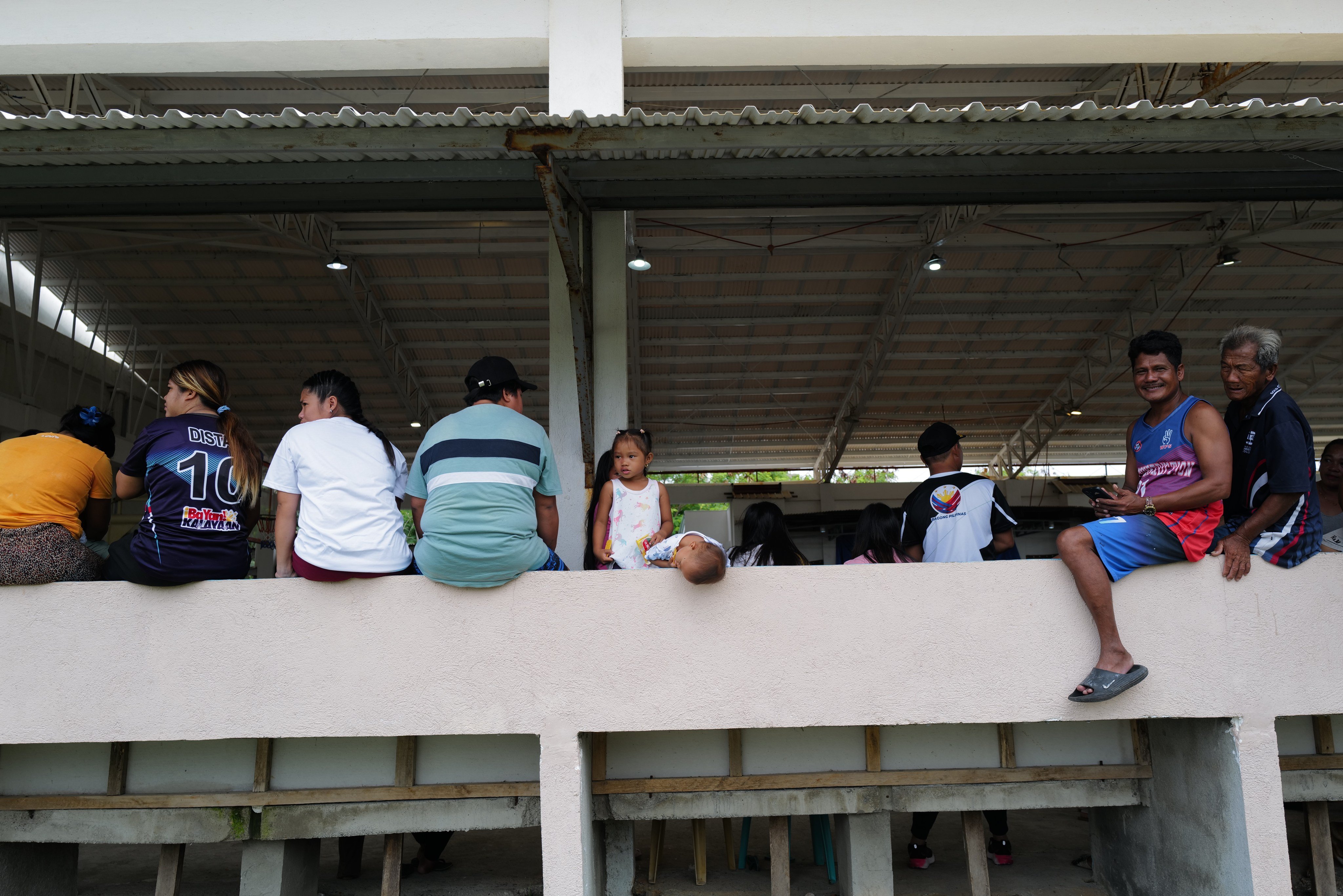 Thitu residents relax inside a covered court. Photo: Jeoffrey Maitem