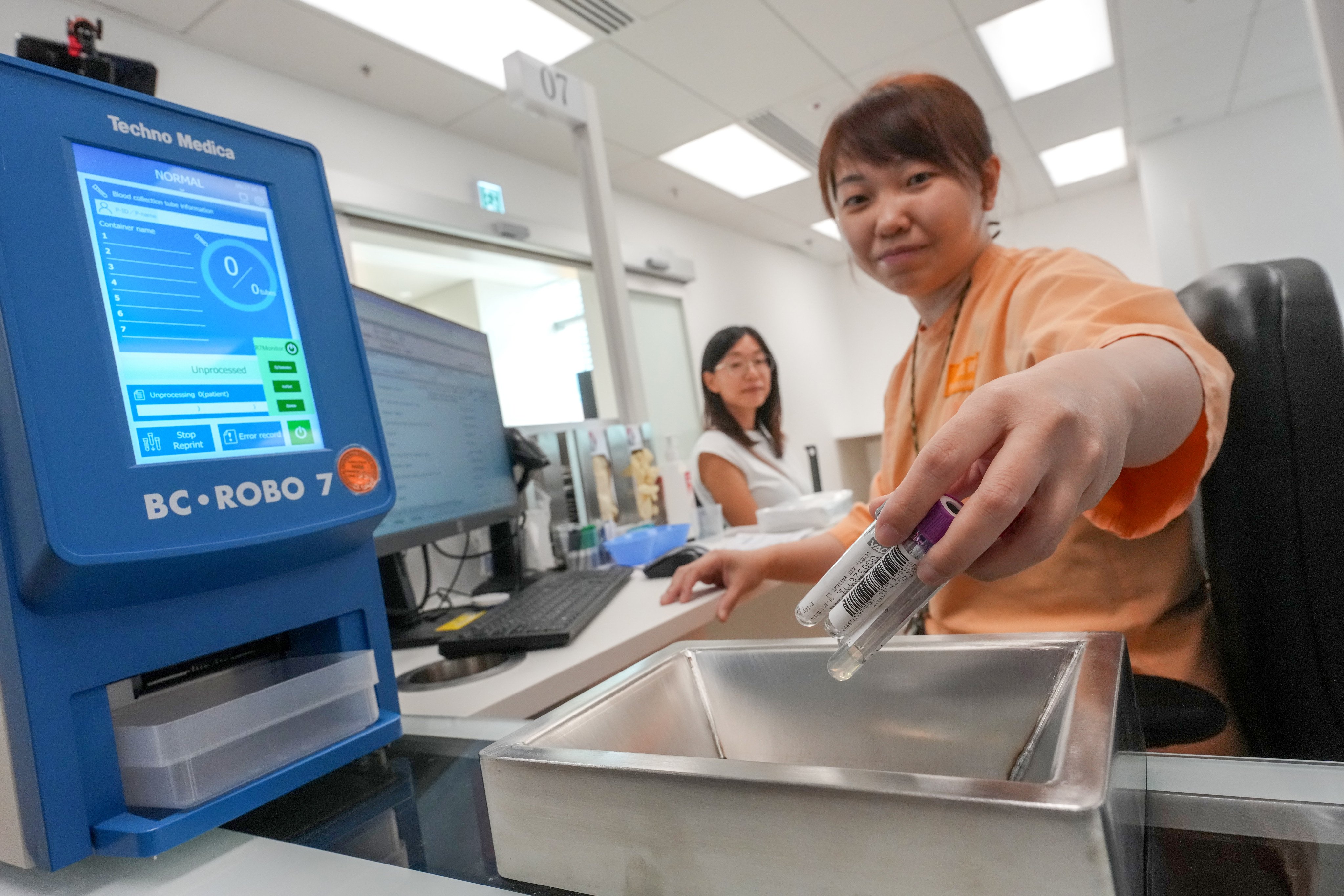 Kai Tak Hospital staff demonstrate the blood-taking process inside the Blood Taking Station. Photo: Kit Lai
