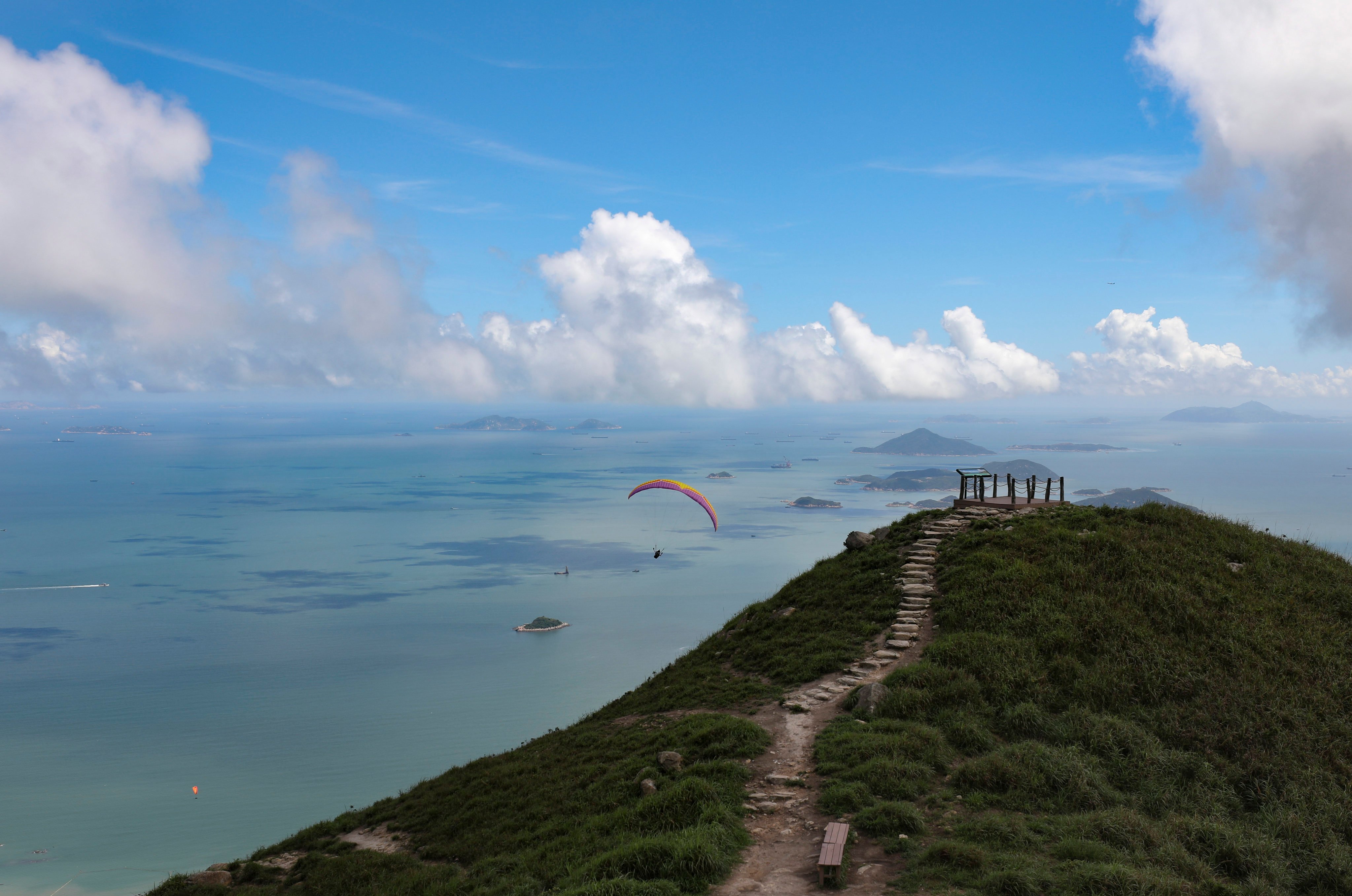 A paraglider flies from Pak Kung Au to Sunset Peak on Lantau. Photo: James Wendlinger