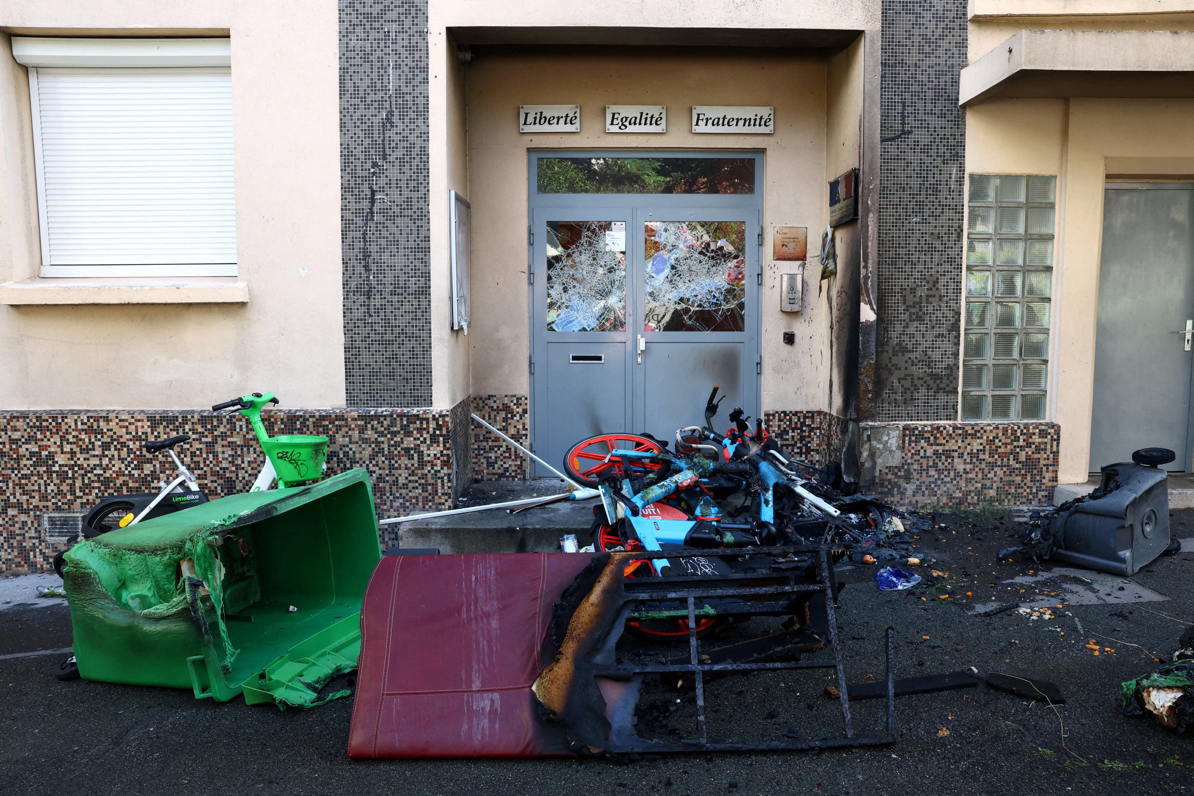 Damaged entrance doors of the Lycee Vauquelin high school with bicycles and garbage bins set on fire by protesters in Paris, France, on Monday. Photo: Reuters
