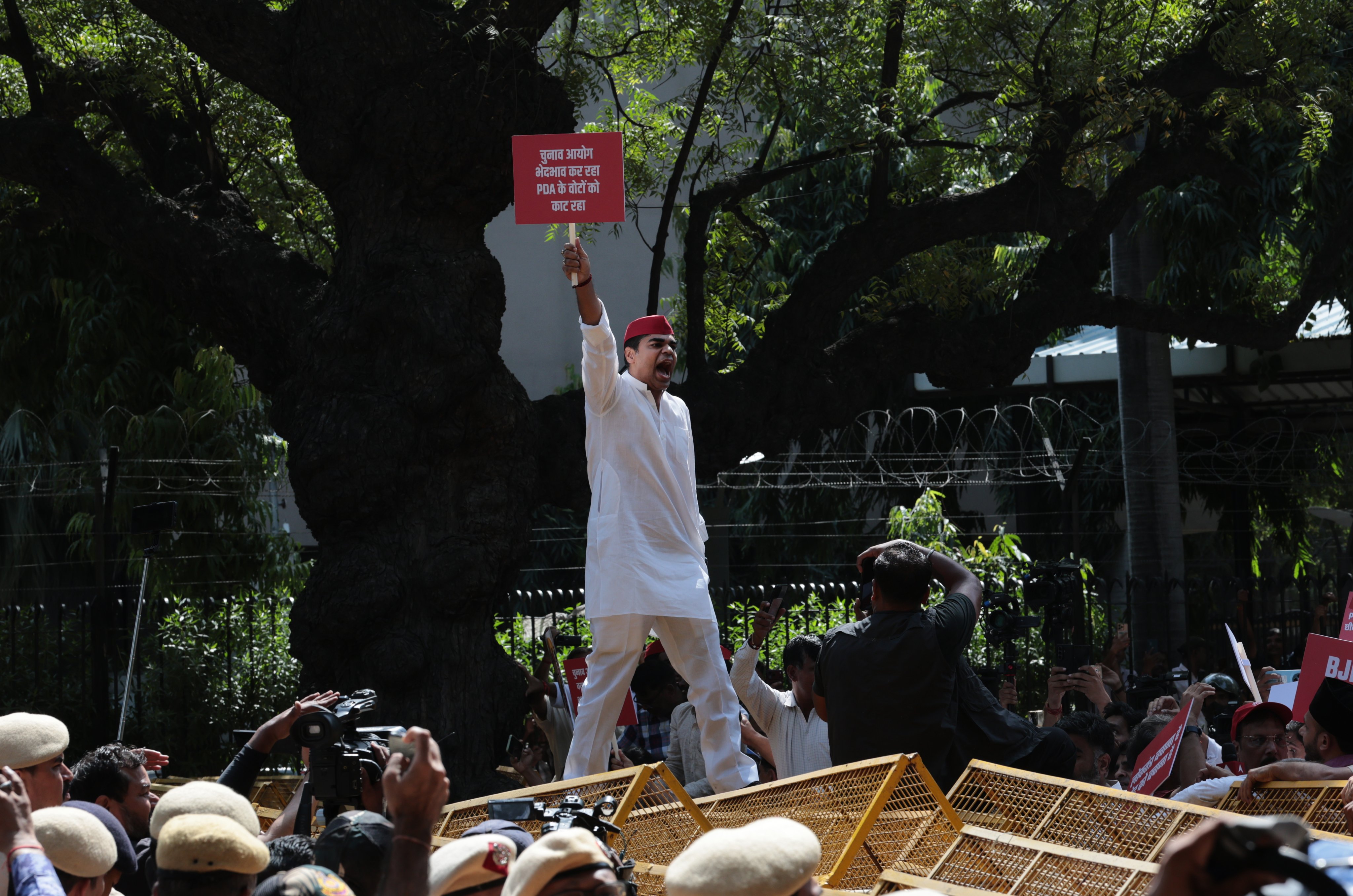 An activist climbs police barricades as Indian National Developmental Inclusive Alliance bloc members of parliament take part in a protest march demanding the resignation of Chief Election Commissioner Gyanesh Kumar in New Delhi on Tuesday. Photo: EPA