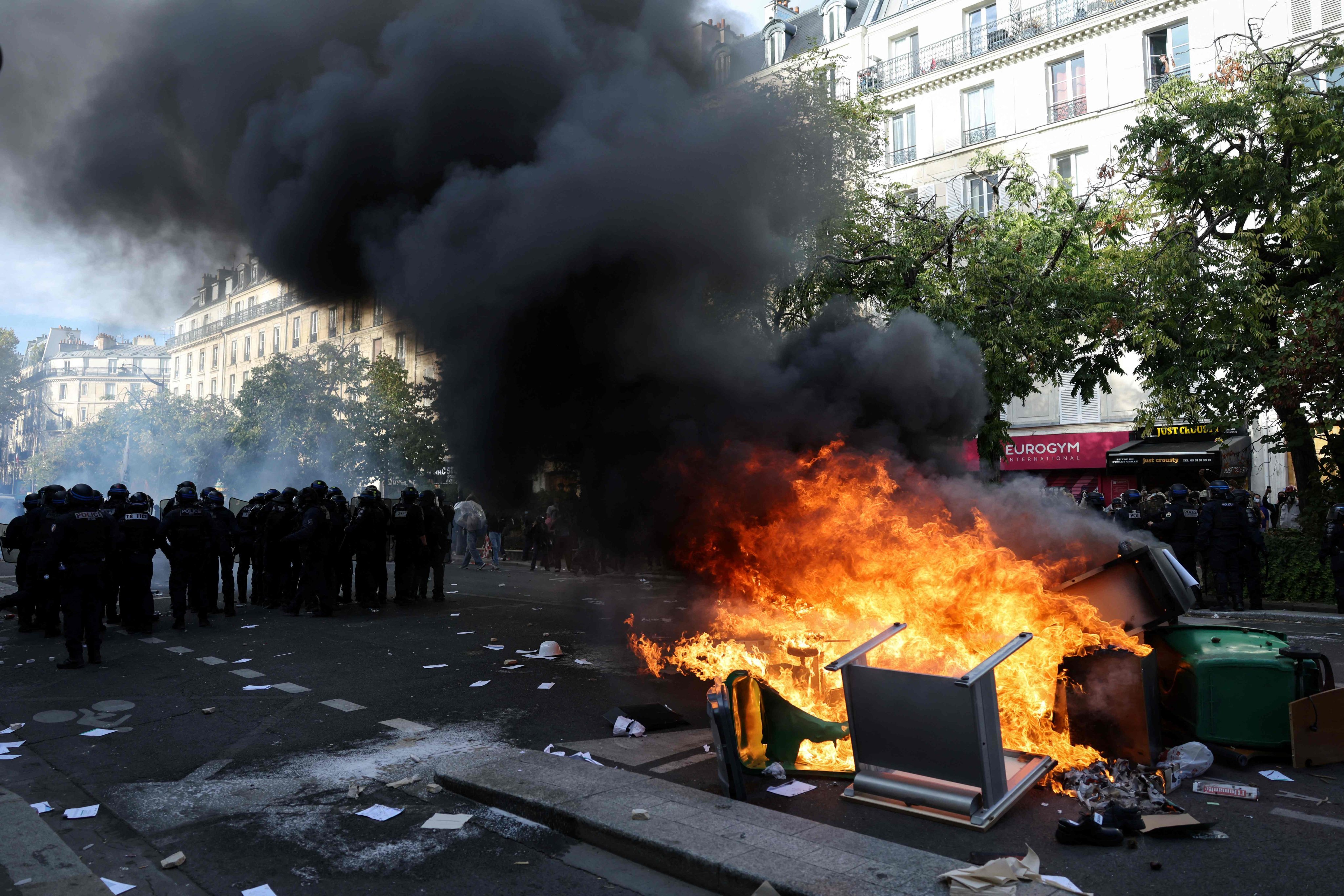 Police stand guard by bins and furniture set on fire in Paris. Photo: AFP