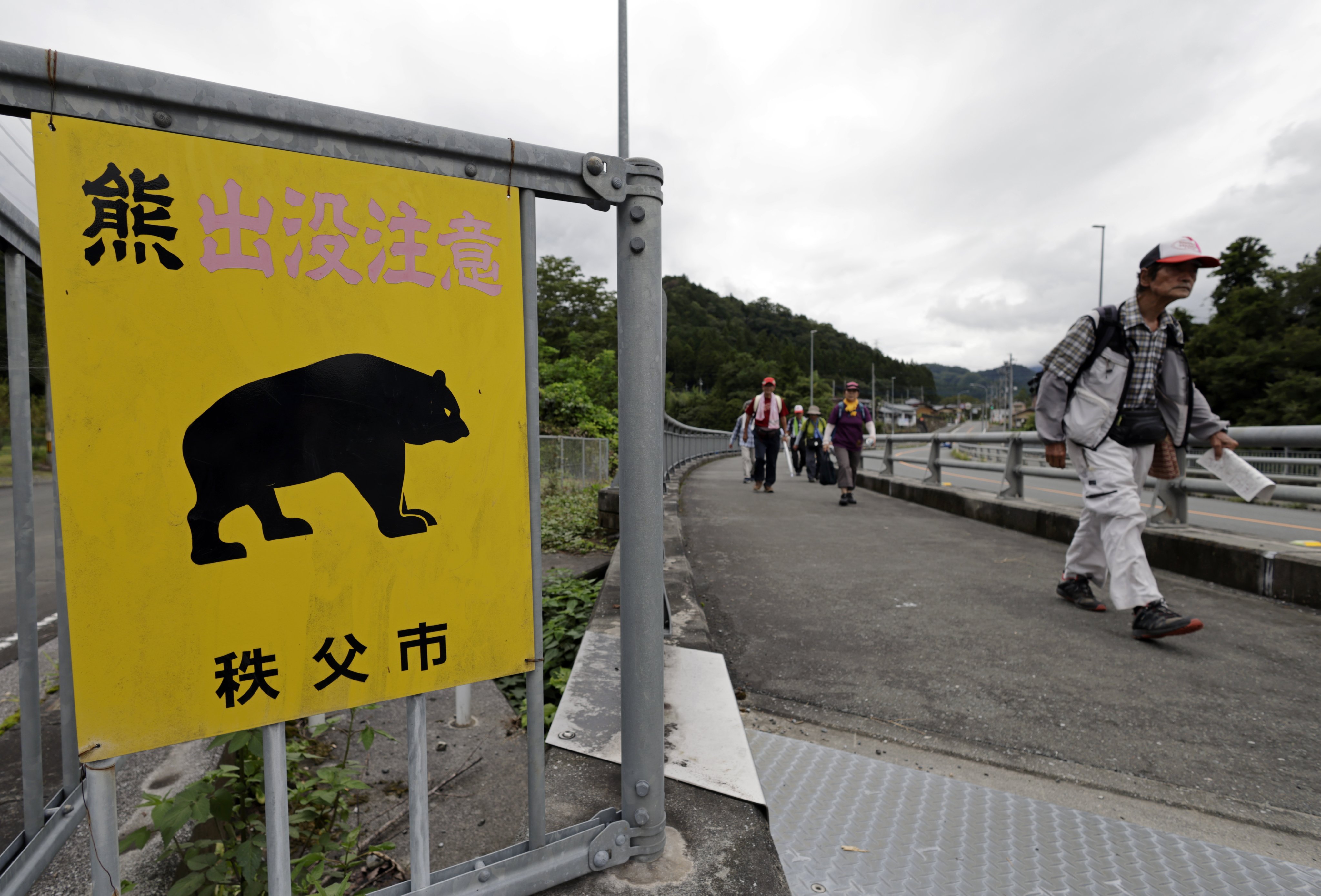 People walk past a sign reading “beware of bears” in Chichibu, Saitama, Japan, last month. Photo: EPA