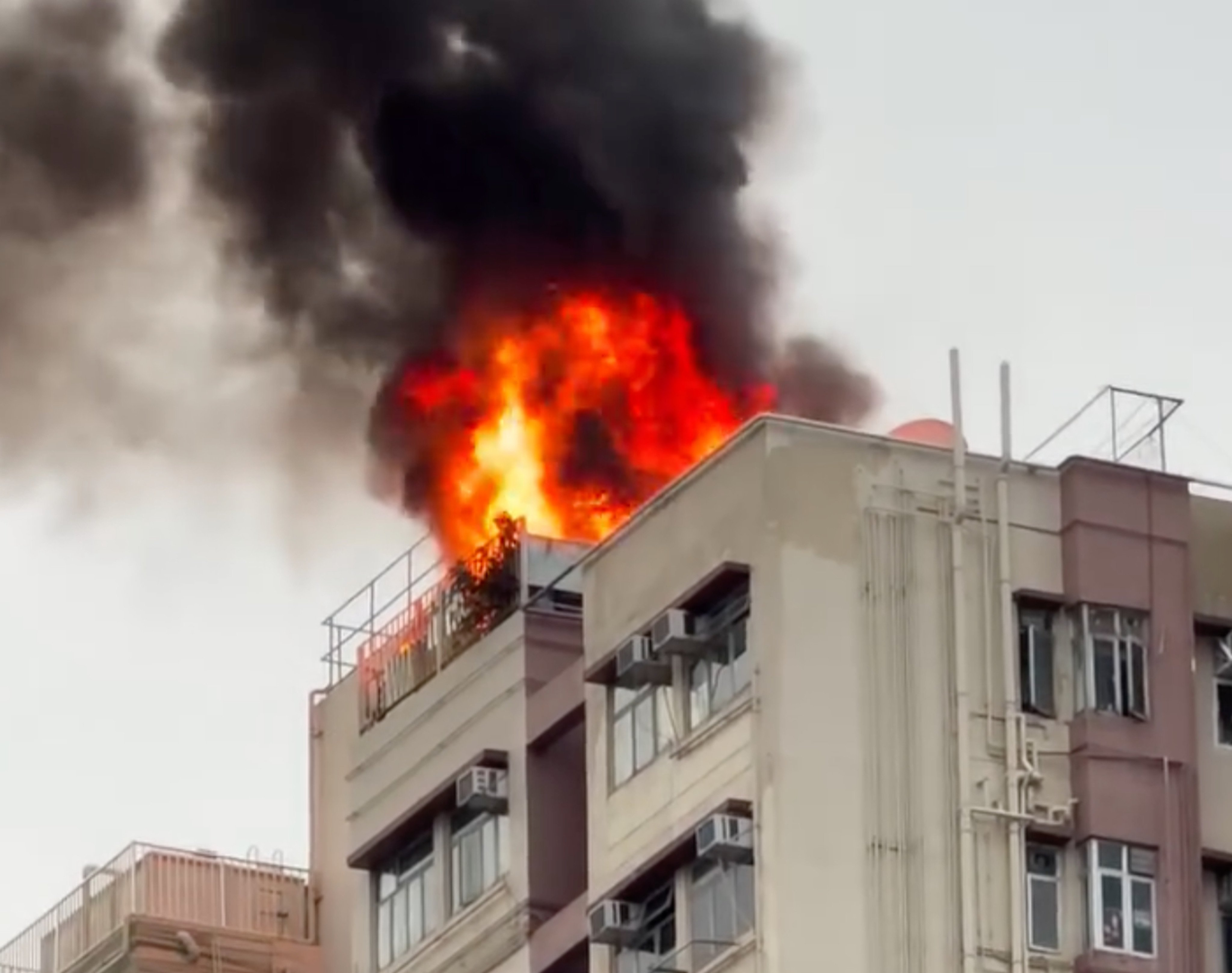 Firefighters are still battling the blaze that broke out on the rooftop a building in Mong Kok. Photo: Handout