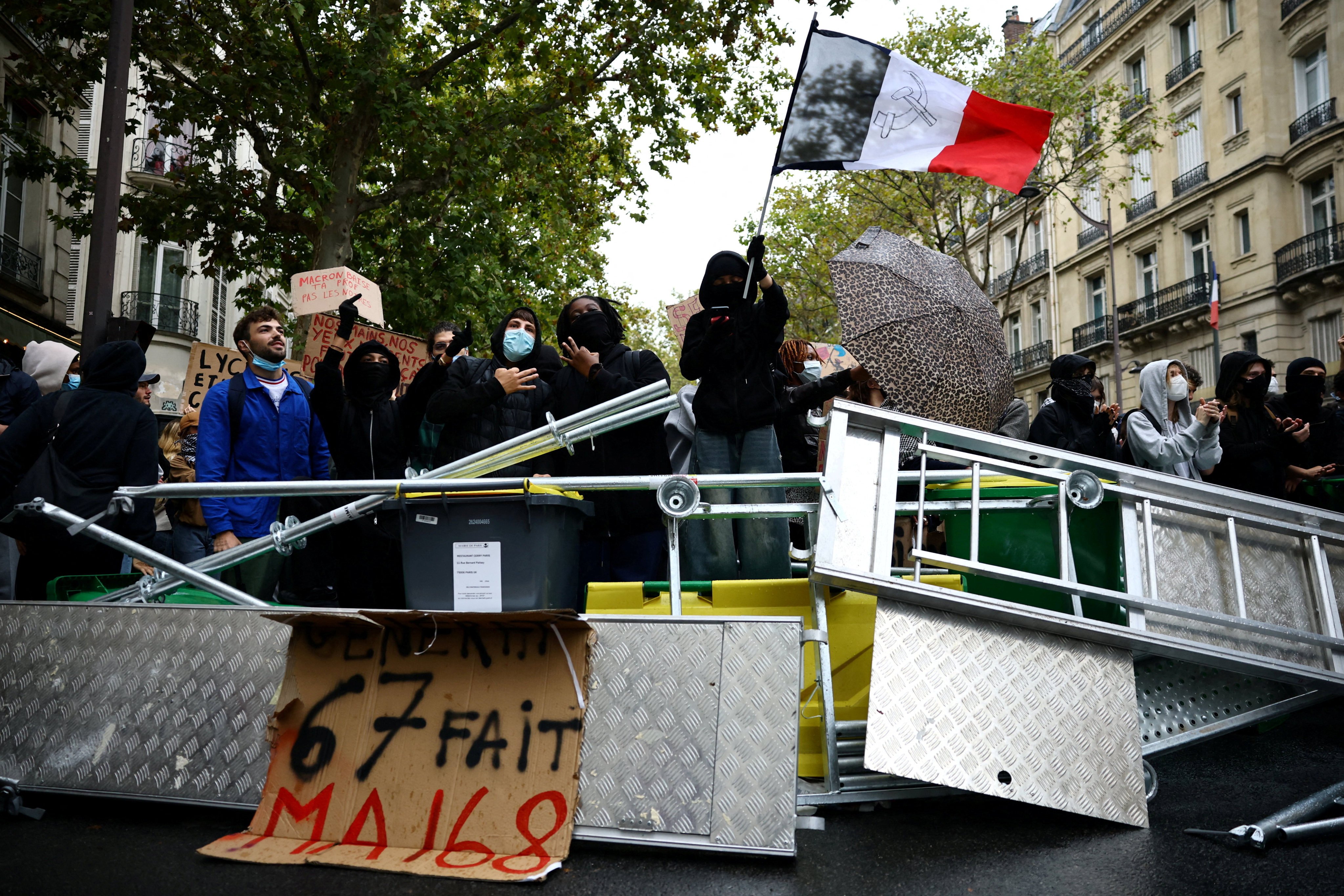 A protester holds a French flag behind a barricade to block the Boulevard Saint-Germain during a blockade of Sciences Po university in Paris on Wednesday. Photo: Reuters