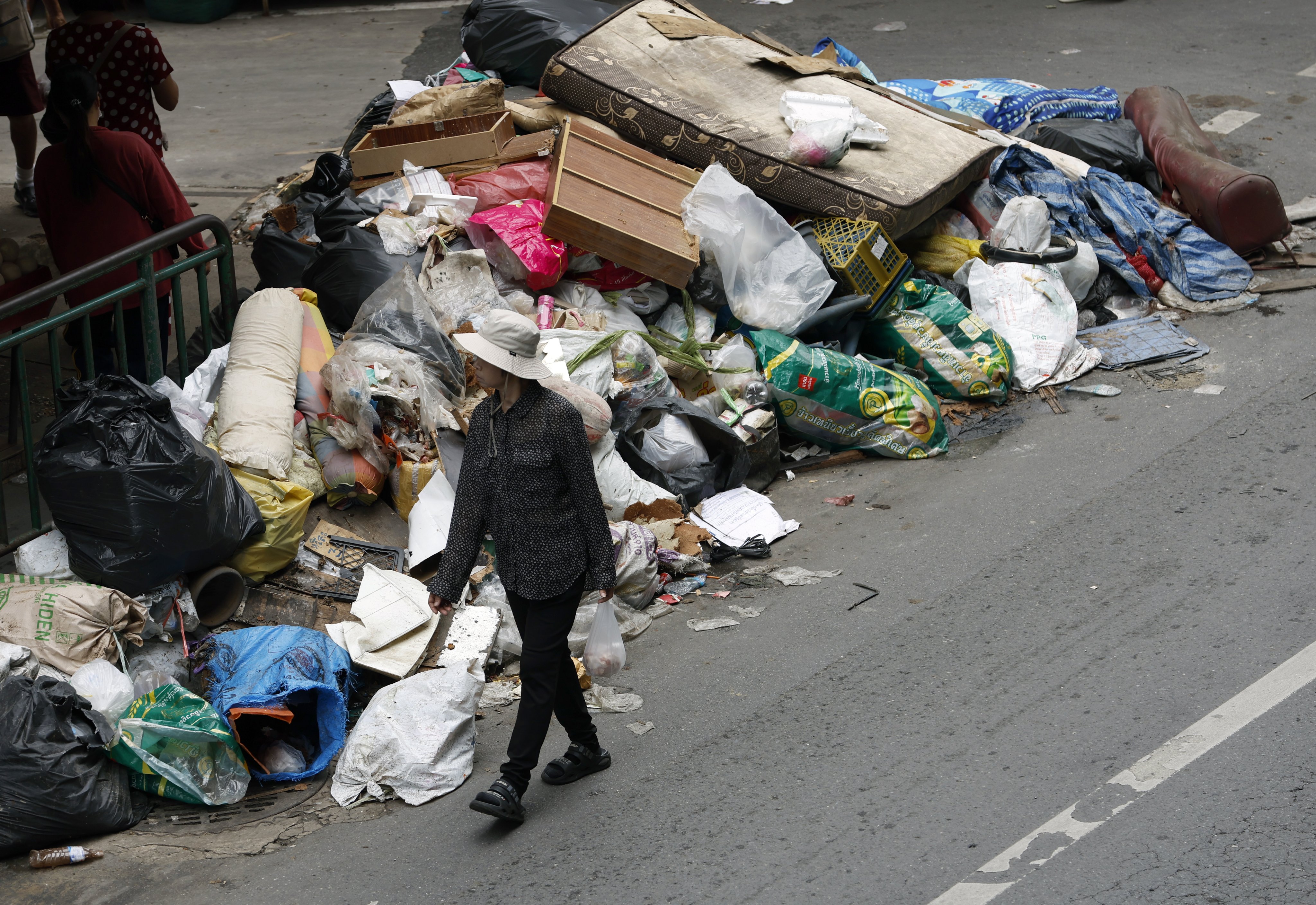A resident passes rubbish accumulated after floodwaters receded at Bangkapi market in Bangkok, Thailand, on Monday. Photo: EPA