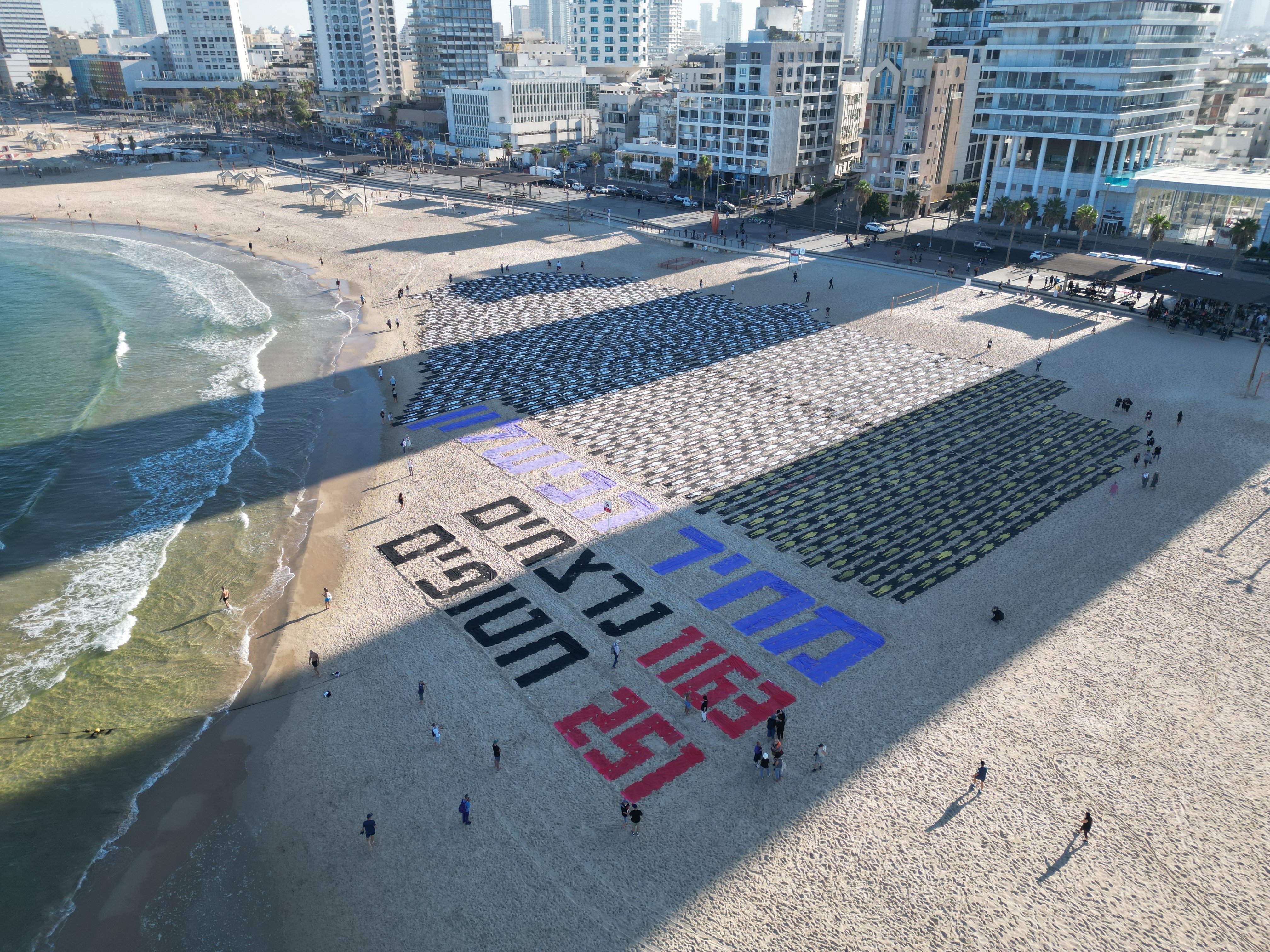Cutouts representing 1,200 victims of the October 7 attack line a Tel Aviv beach next to Hebrew letters spelling 'Total Failure'. Photo: EPA