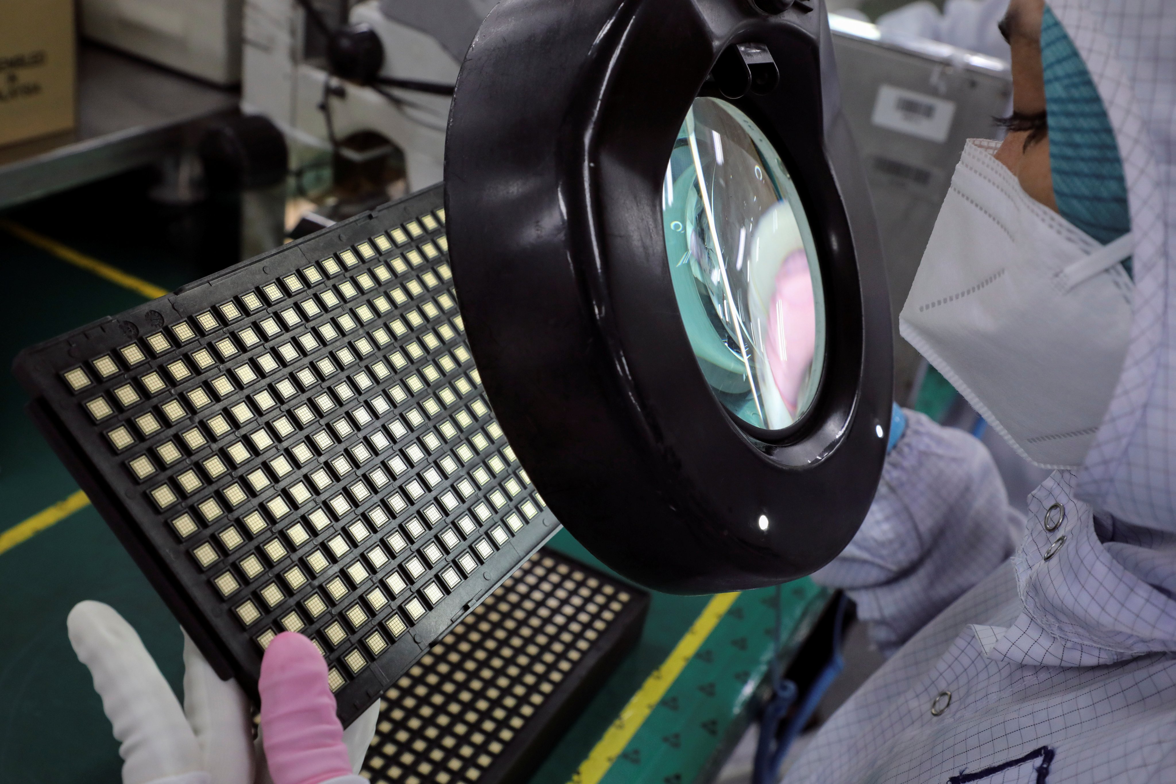 A worker inspects semiconductor chips at a plant in Ipoh, Malaysia. Photo: Reuters