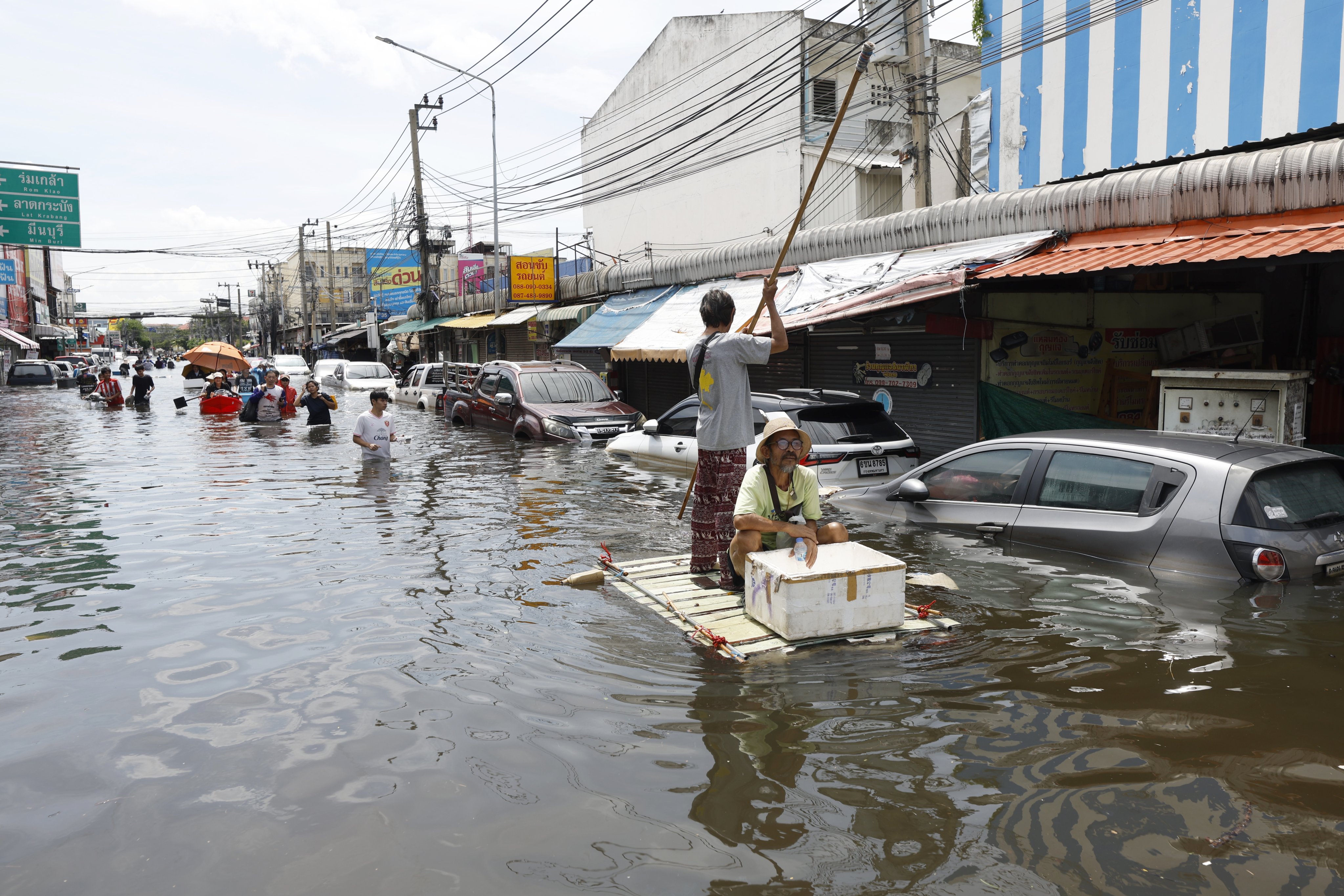 Residents collect food supplies in flooded Lat Krabang district, Bangkok, Thailand, on September 29. Photo: EPA