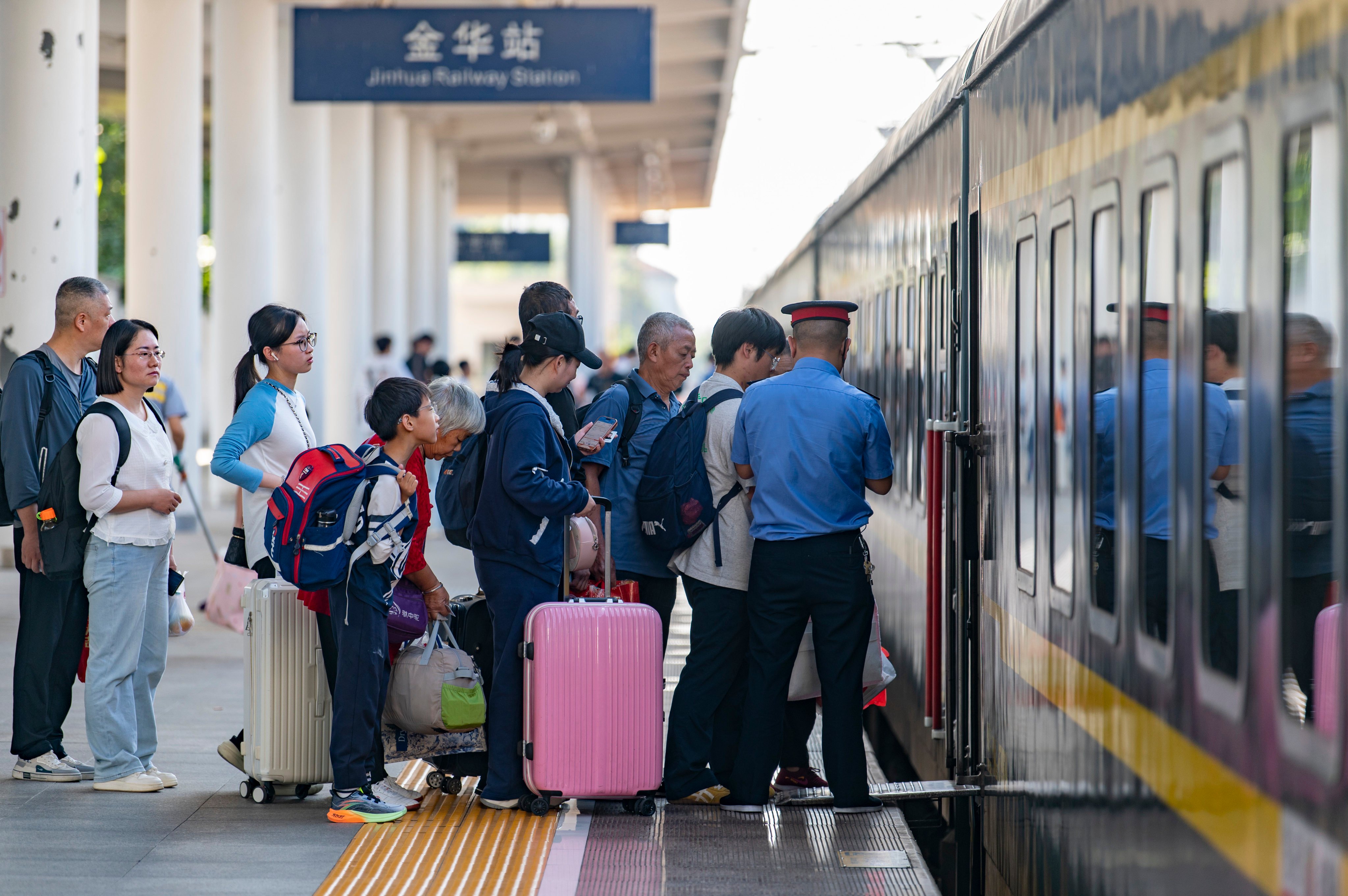 Passengers board a train at Jinhua Railway Station in Zhejiang province on Wednesday. Photo: Xinhua