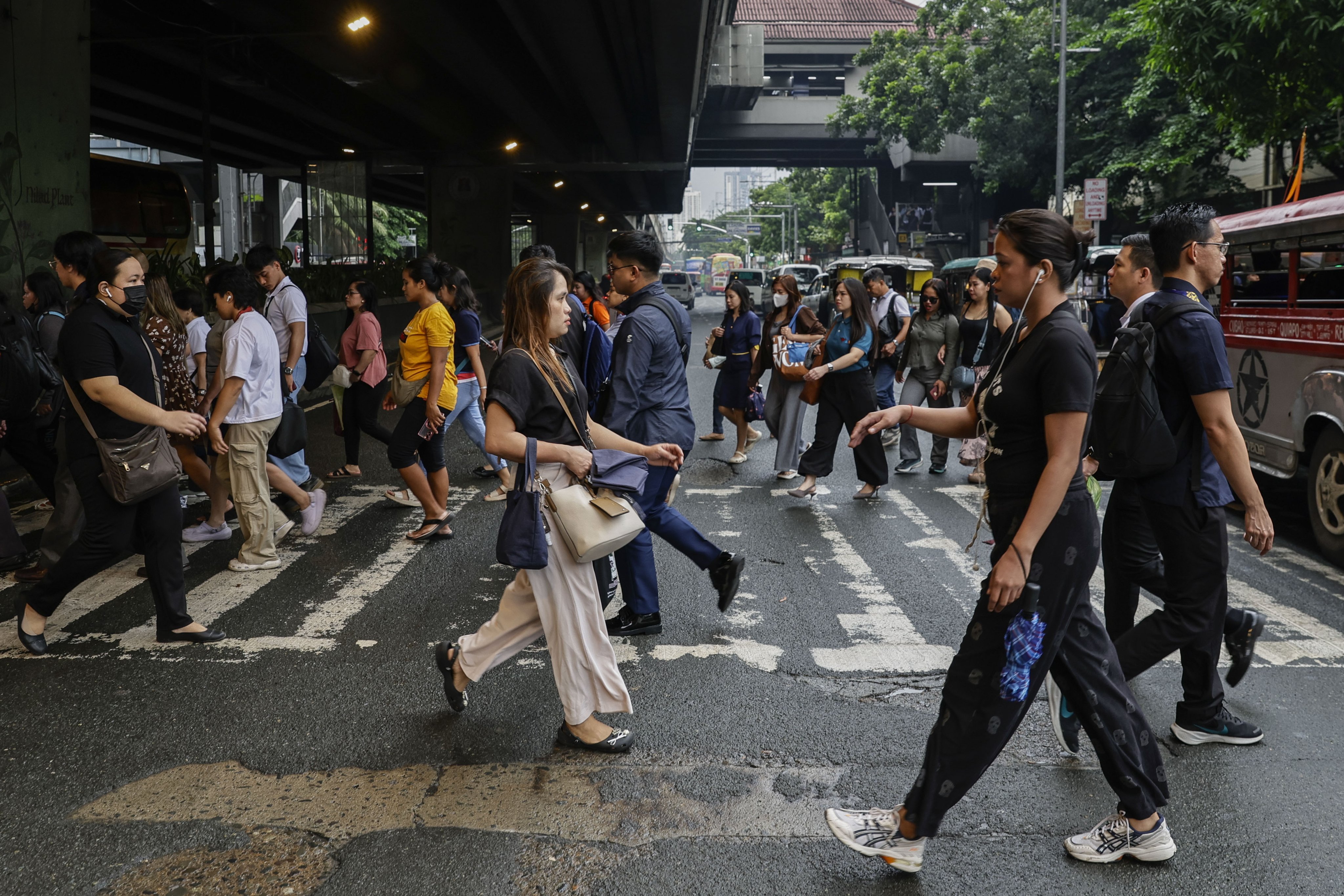 People cross a road in Manila. The Asian Development Bank Institute has urged the Philippines to provide targeted support for the middle class to protect its purchasing power. Photo: EPA