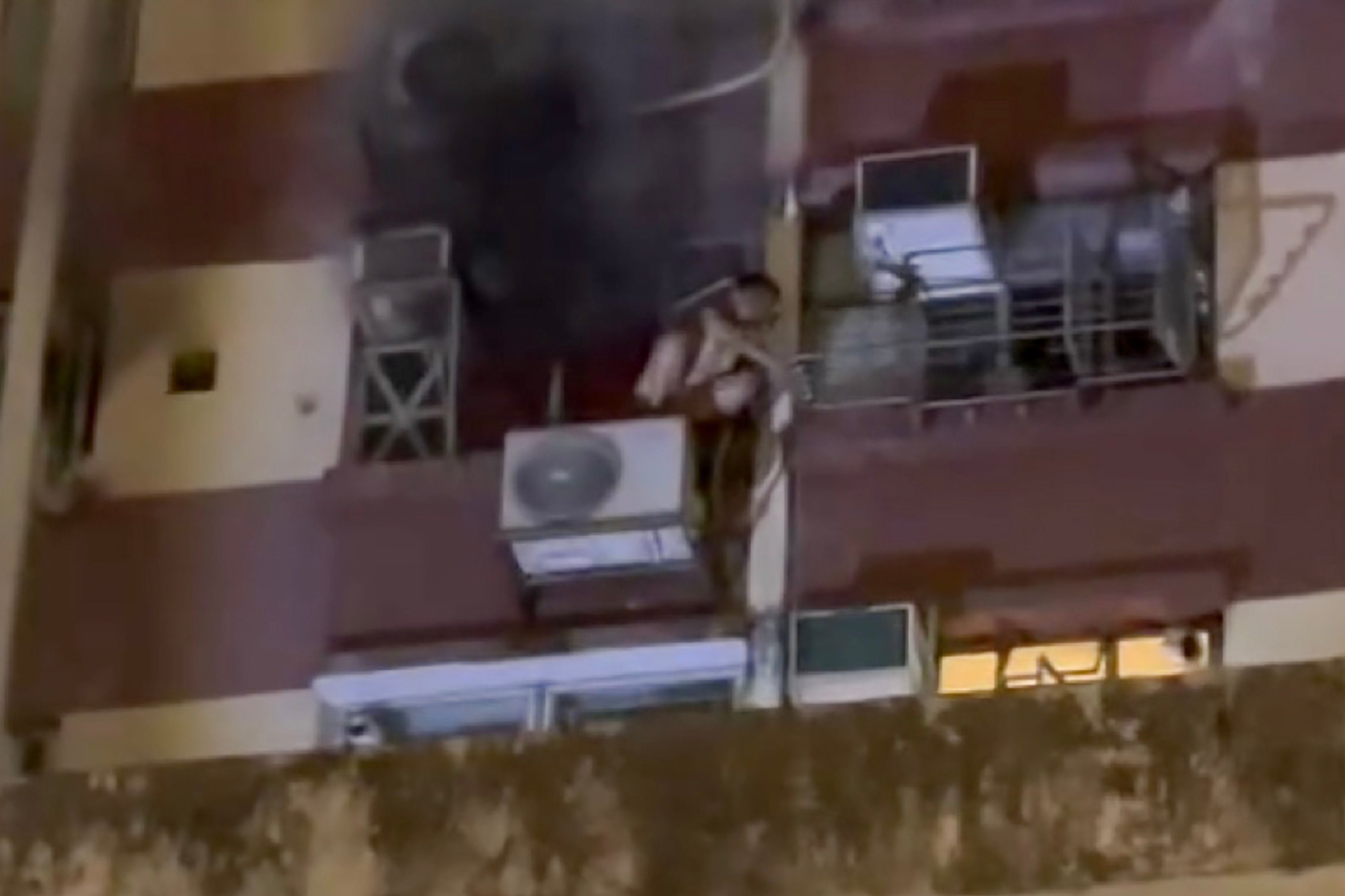 Online footage showed the 13-year-old boy climbing out of a window and onto the air-conditioning condenser unit to escape the fire in his flat. Photo: Threads/ckm_nancy
