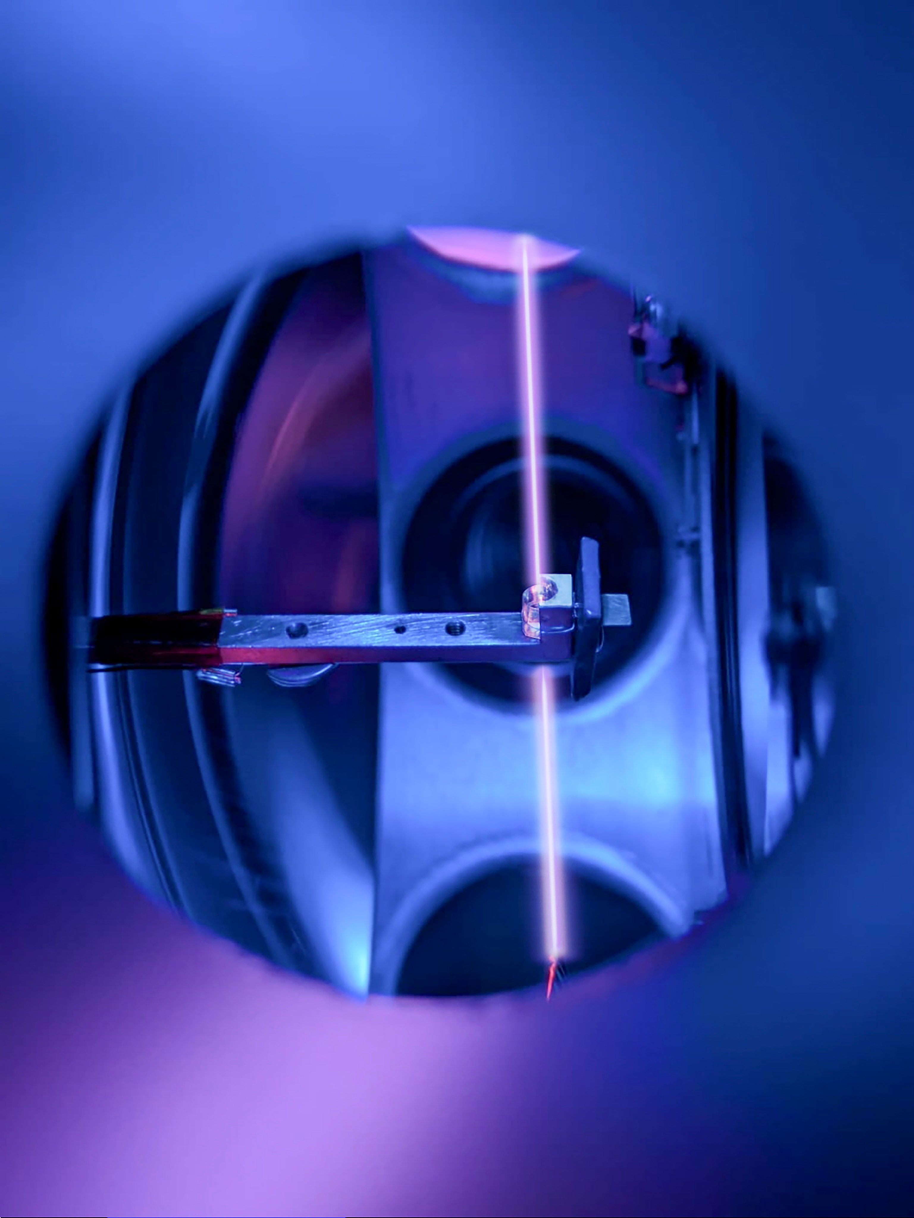 The crystal used in the Vienna team’s nuclear clock, pictured in its holder with the laser beam probing the thorium nuclei. Photo: TU Wien