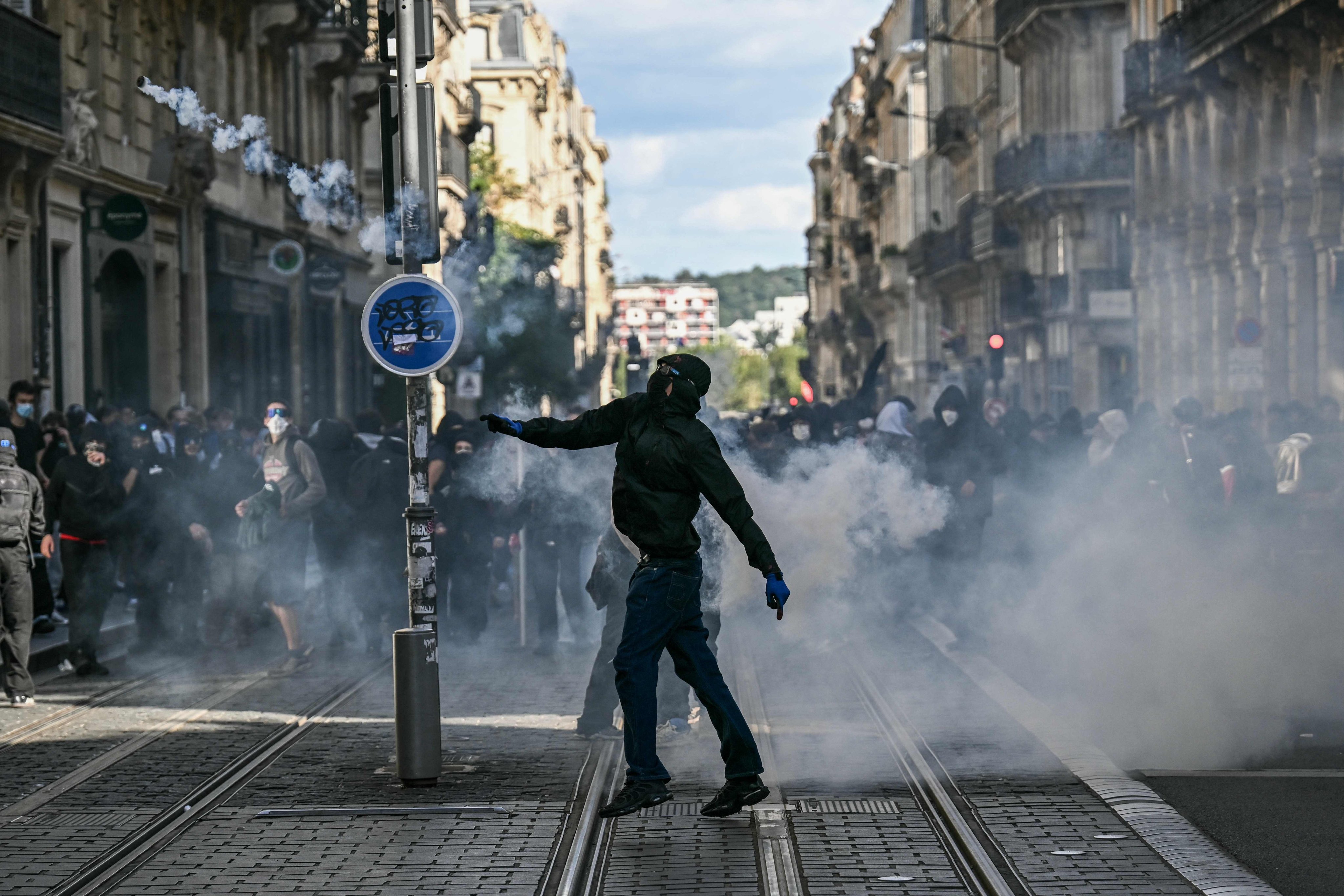 A protester throws back a tear gas canister fired by police during a demonstration of high school students in Bordeaux, France, on Thursday. Photo: AFP