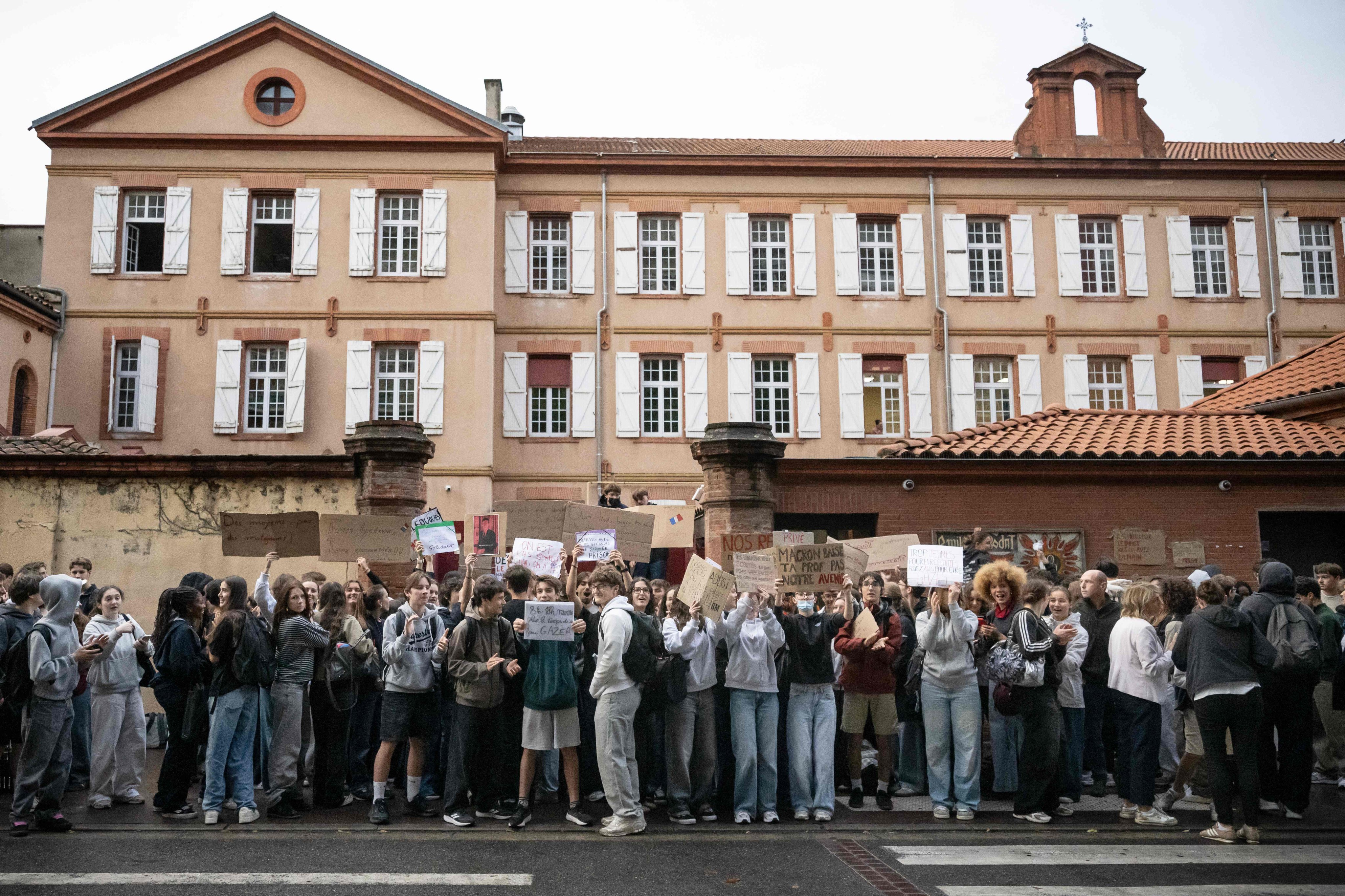 Protesters hold placards during a blockade of private high school Emilie de Rodat in Toulouse, France, on Thursday. Photo: AFP