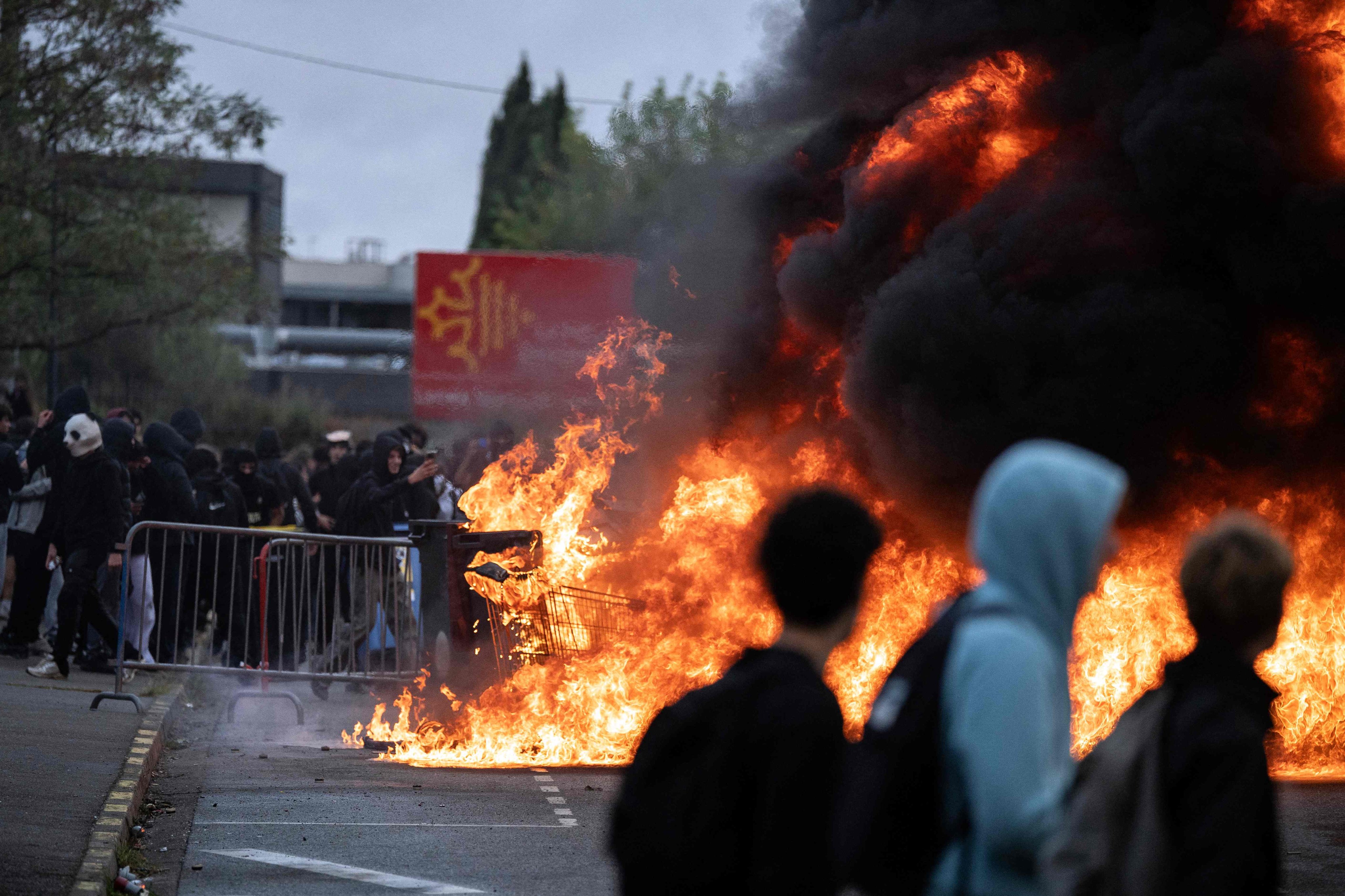 Protesters gather as trash cans burn during a blockade of high school Toulouse-Lautrec in Toulouse, France, on Thursday. Photo: AFP