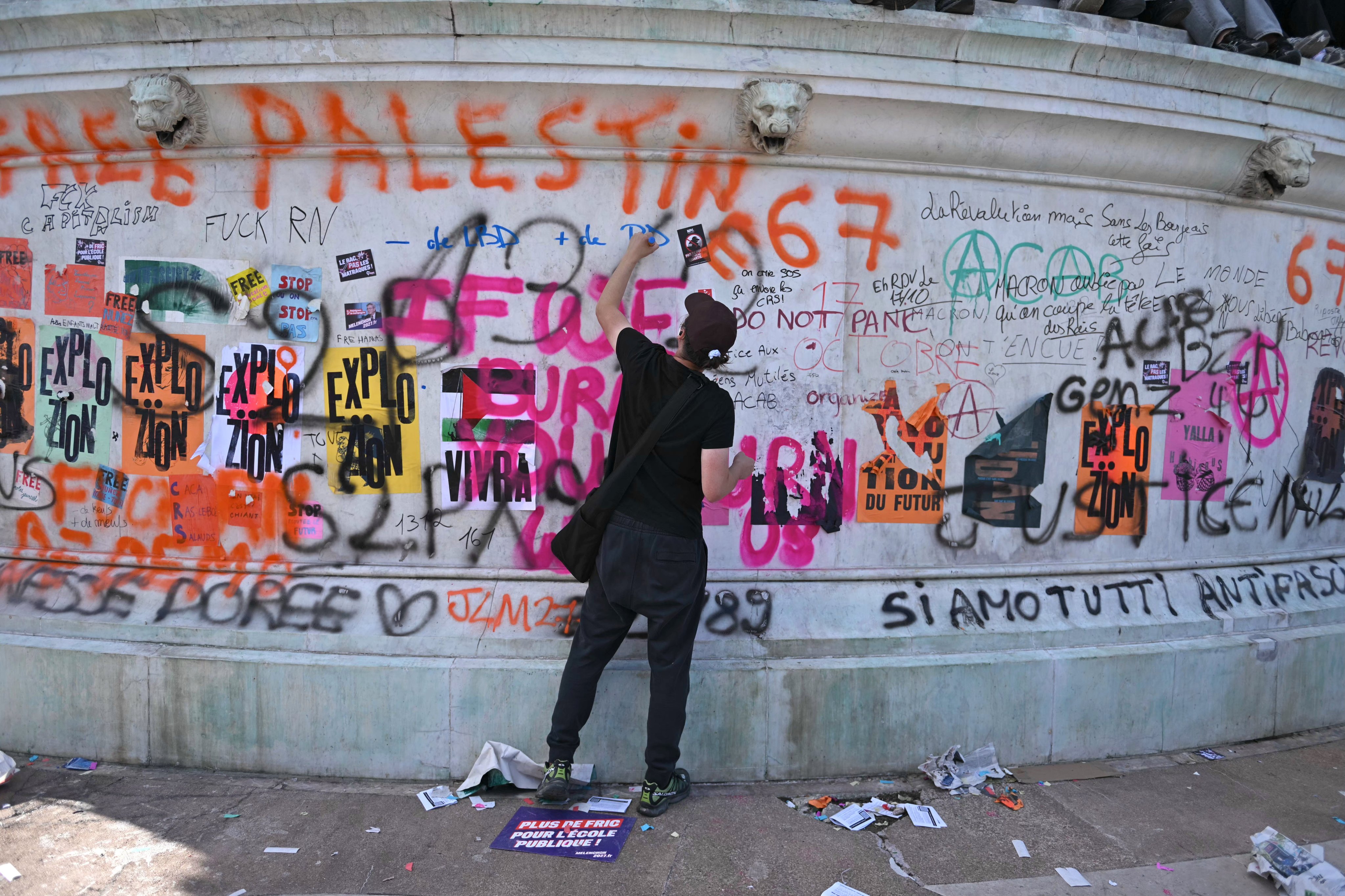 A protester write slogans on the Bastille column during a demonstration over school conditions in Paris, France, on Thursday. Photo: EPA