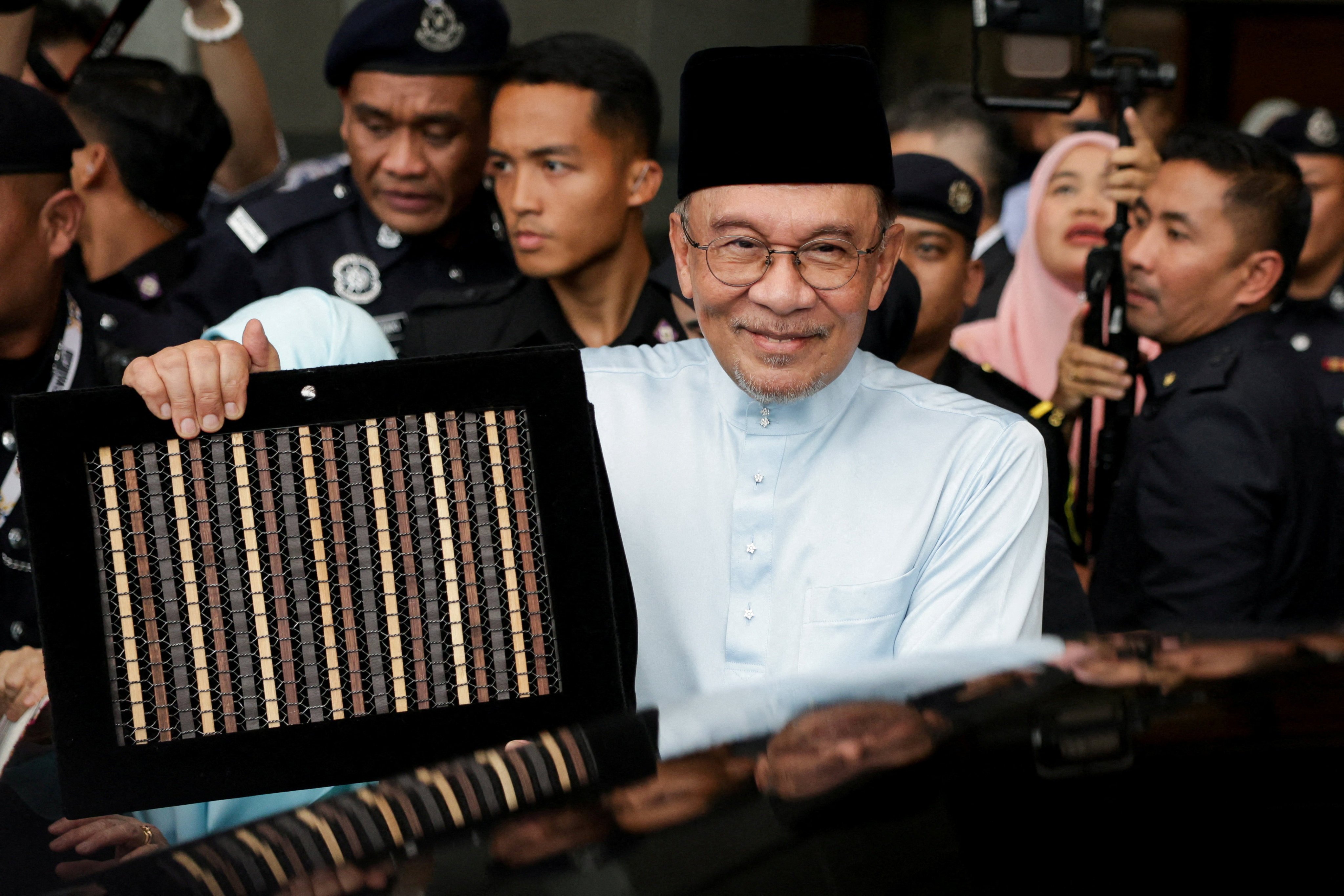 Malaysia’s Prime Minister and Finance Minister Anwar Ibrahim holds the 2027 national budget document as he heads to parliament to table the budget in Putrajaya on Friday. Photo: Reuters