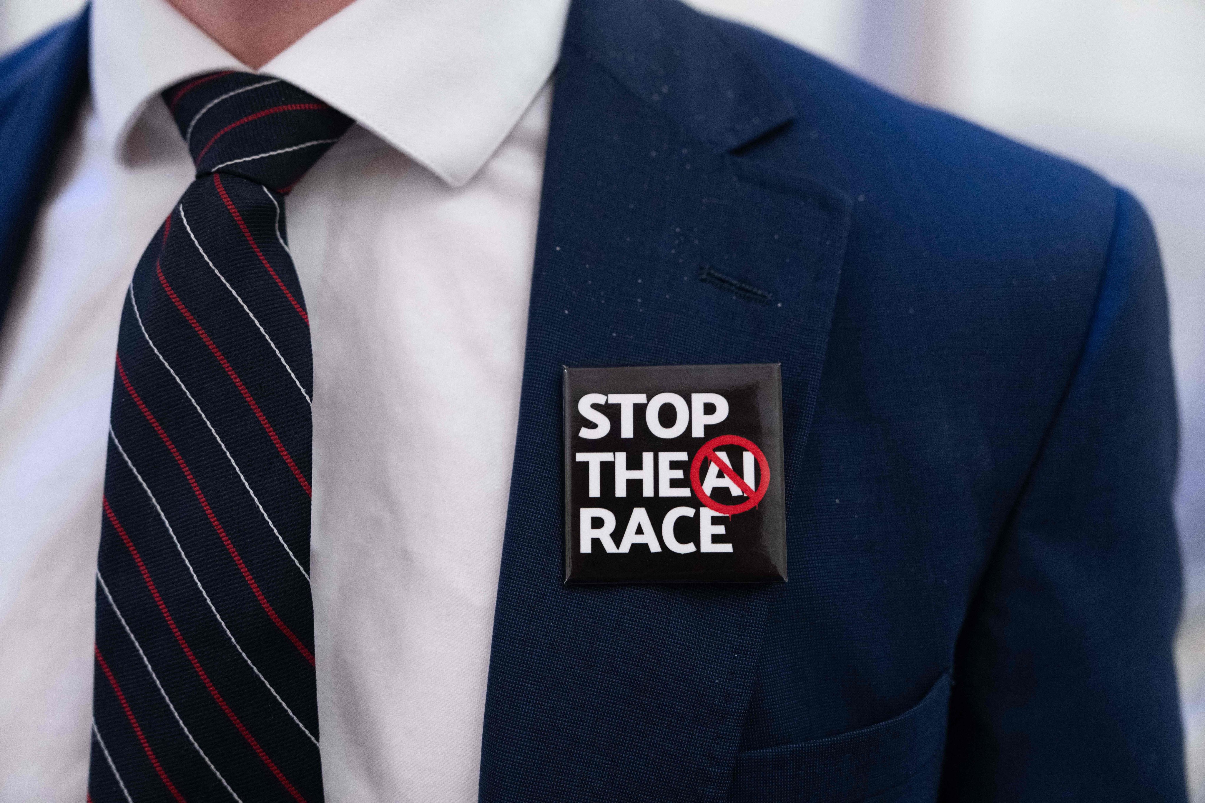 A person wears a “Stop the AI Race” badge outside a New York City Council hearing on the risks and regulation of artificial intelligence at City Hall in New York on October 5. Photo: Getty Images via AFP