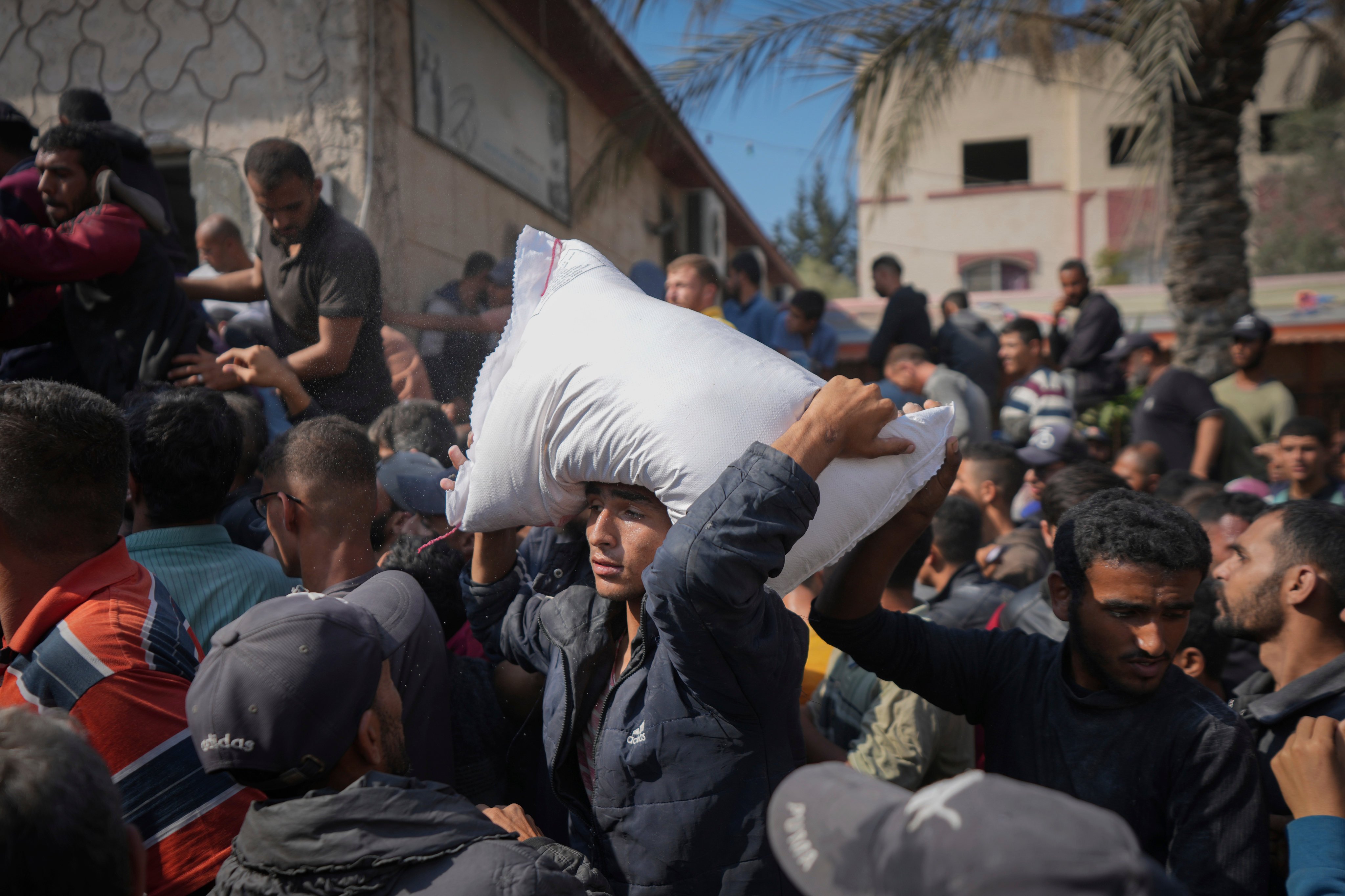 Palestinians gather to receive bags of flour distributed by the UN Relief and Works Agency for Palestine Refugees in the Near East in Deir al Balah, in the Gaza Strip, in November 2024. Photo: AP